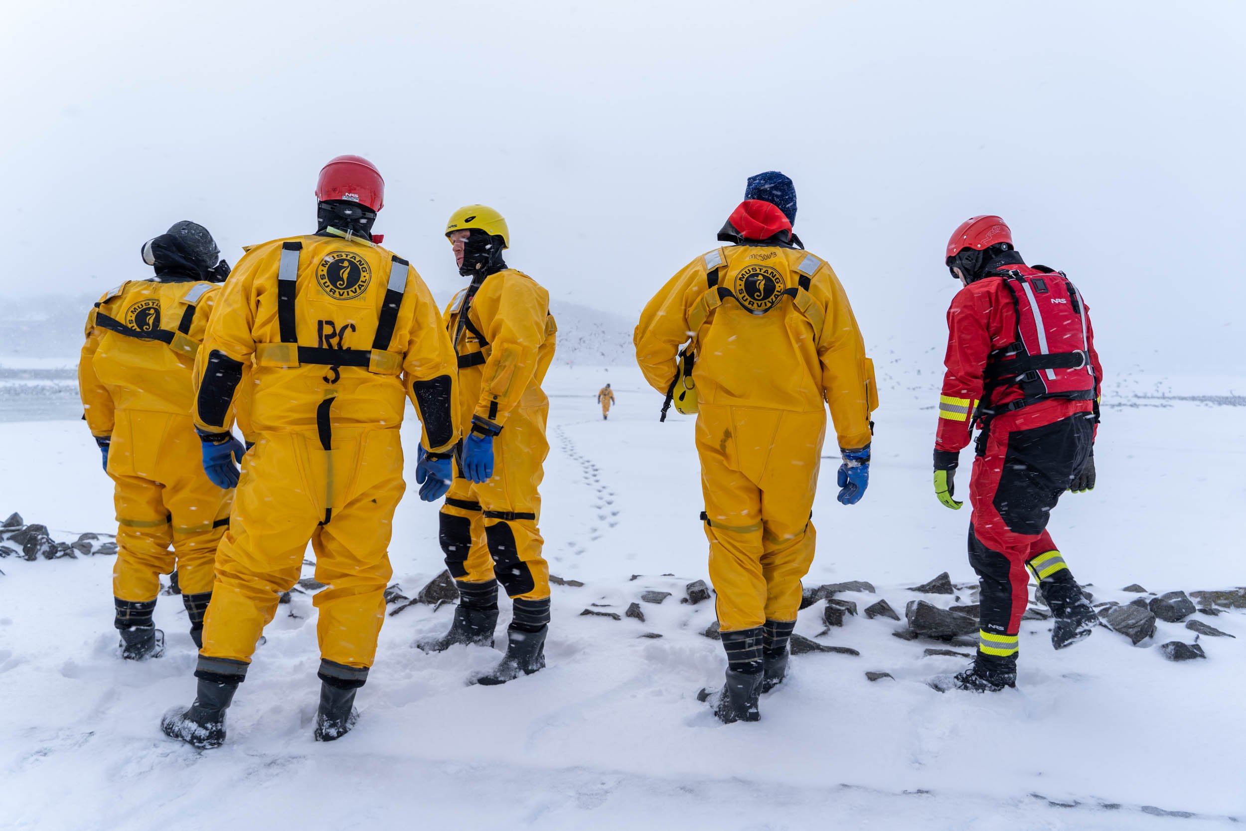 Matt Aman, John Champion, Kevin Holihan, Unknown, Unknown, and Tyler Makoravitz of the Irondeqouit Fire Station train for ice rescues in Irondequoit Bay, NY on February 18, 2022. New York firefighters train for ice rescues once a year and spend an h