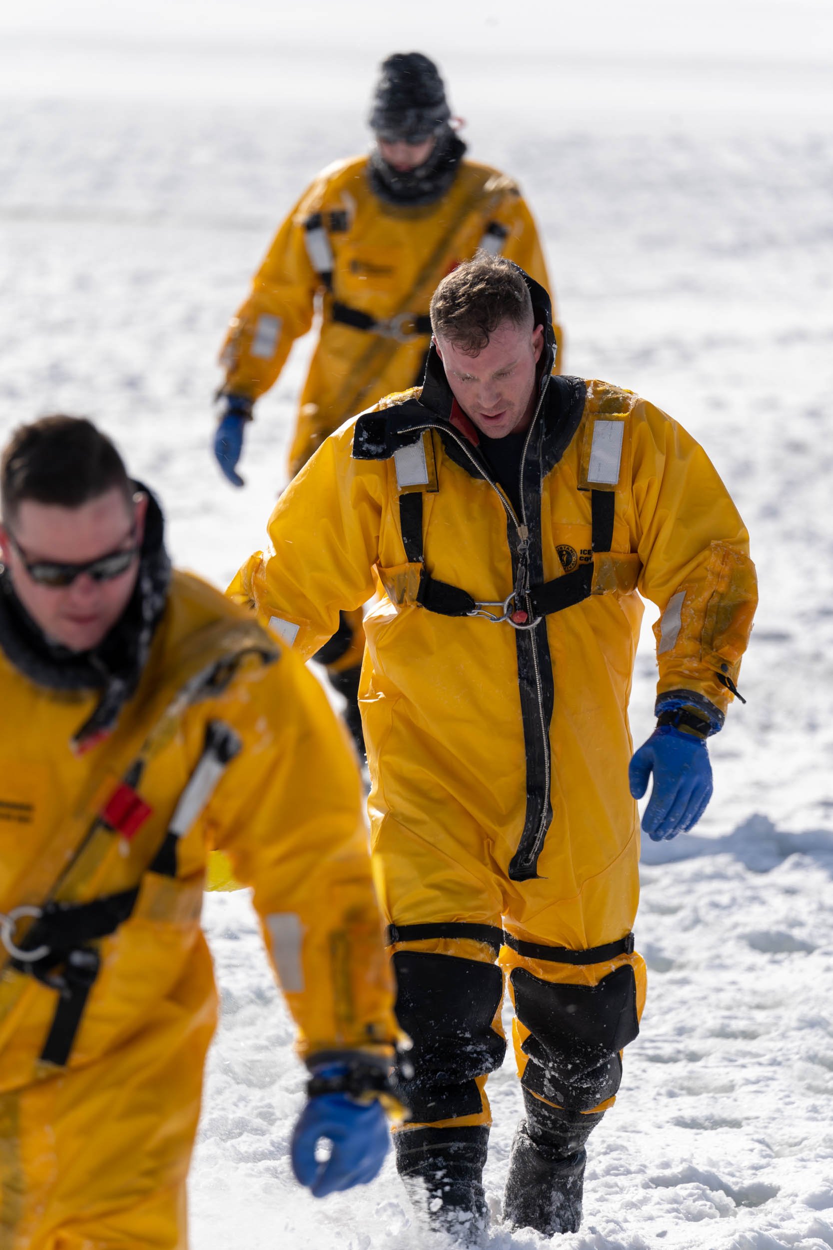 Unknown, Kevin Holihan, and Andy Beyer, members of the Irondequoit Fire Station, train for ice rescues in Irondequoit Bay, NY on February 18, 2022. New York firefighters train for ice rescues once a year and spend an hour out in the freezing tempera