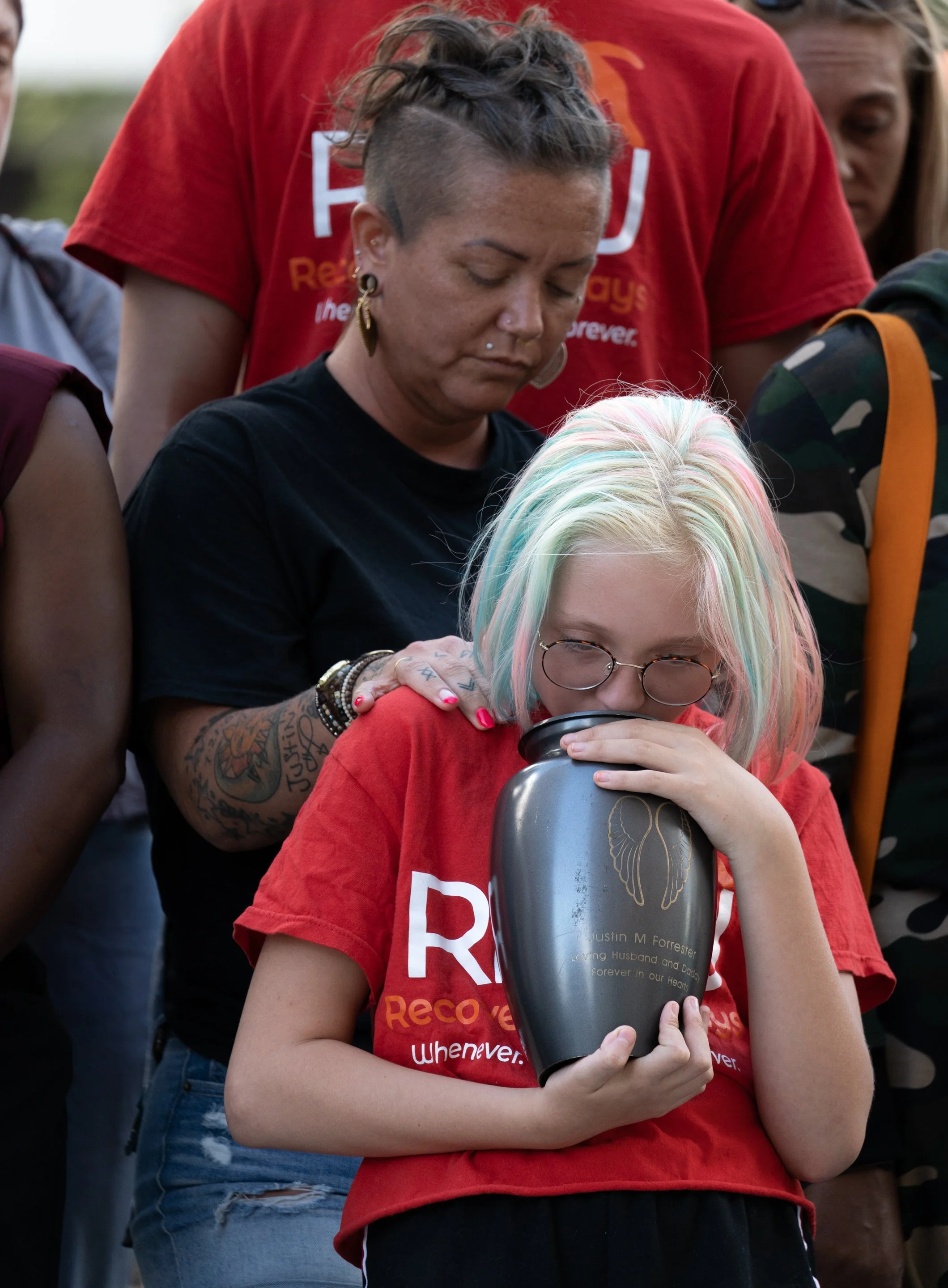  Stephanie Forrester comforts her daughter, Bella Forrester who holds her father, Justin Forrester’s, ashes who died of an overdose in 2017 during an overdose vigil in Rochester, N.Y. on August 31, 2022.  
