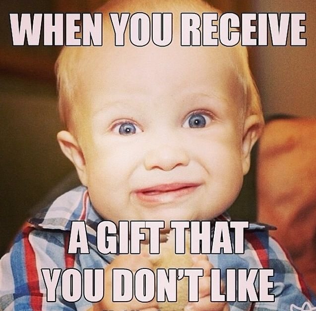 Baby with stressed smile receiving bad gift.