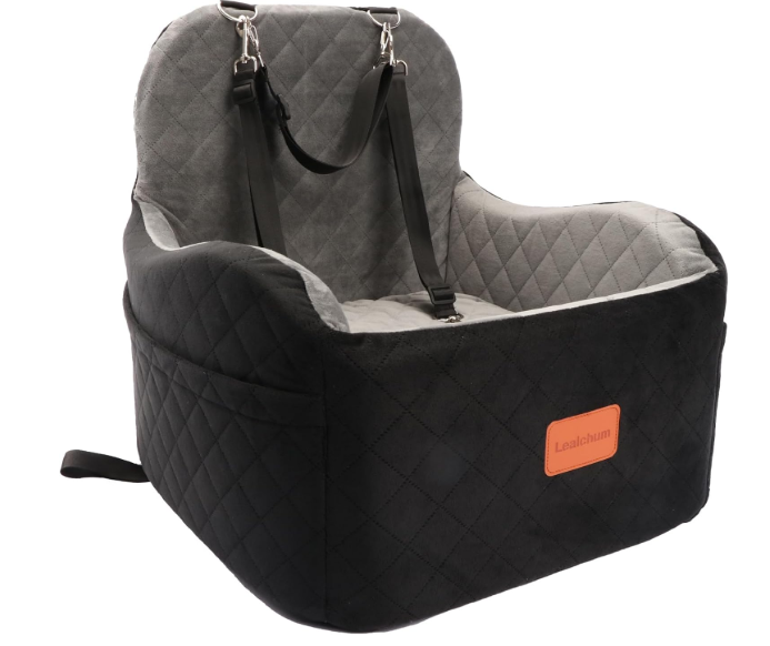 Black and gray padded booster seat with a harness and an orange label that reads 'Leachum'