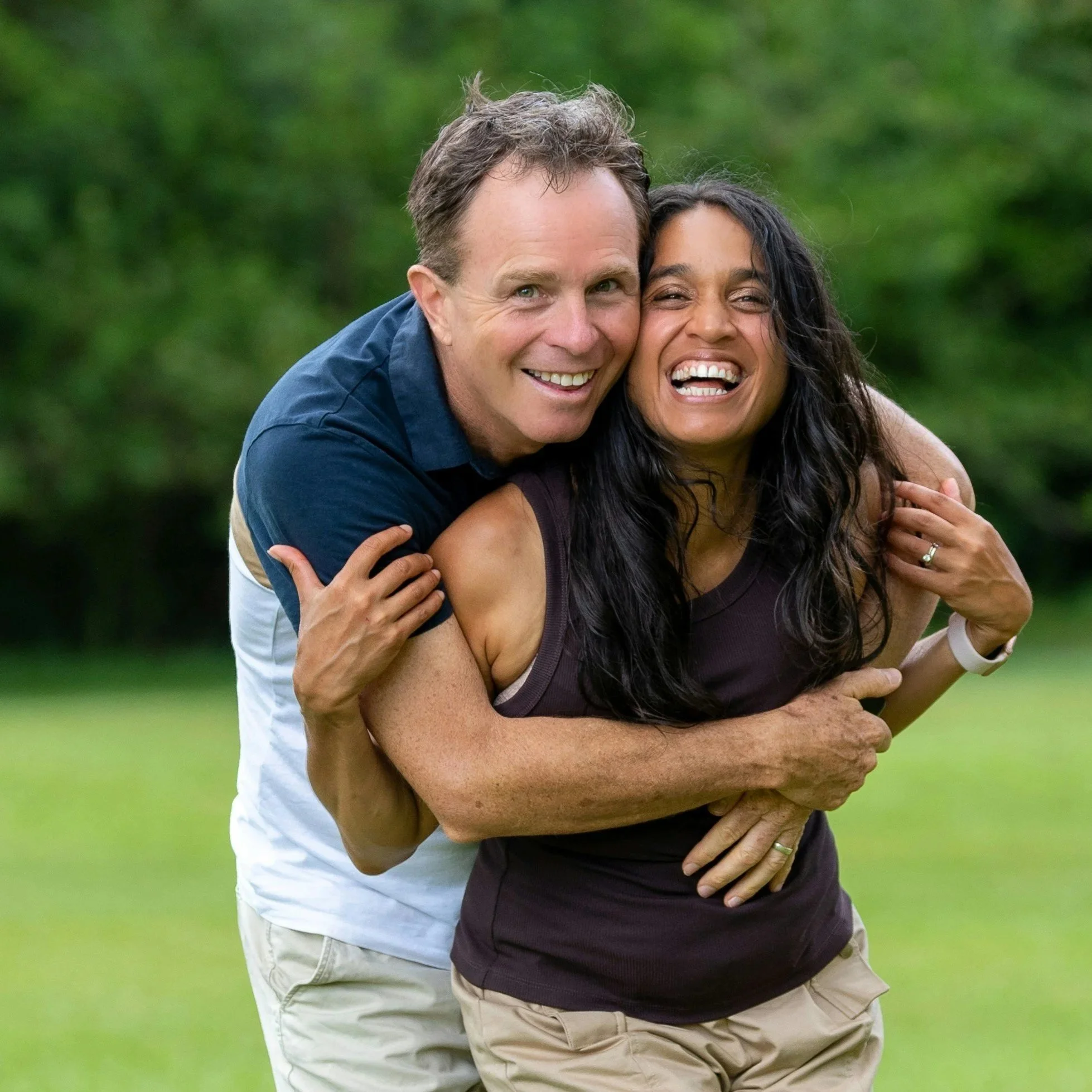 Silhouettes of a person and a child on a rocky ledge; the person is holding the child and the child is pointing into the distance.