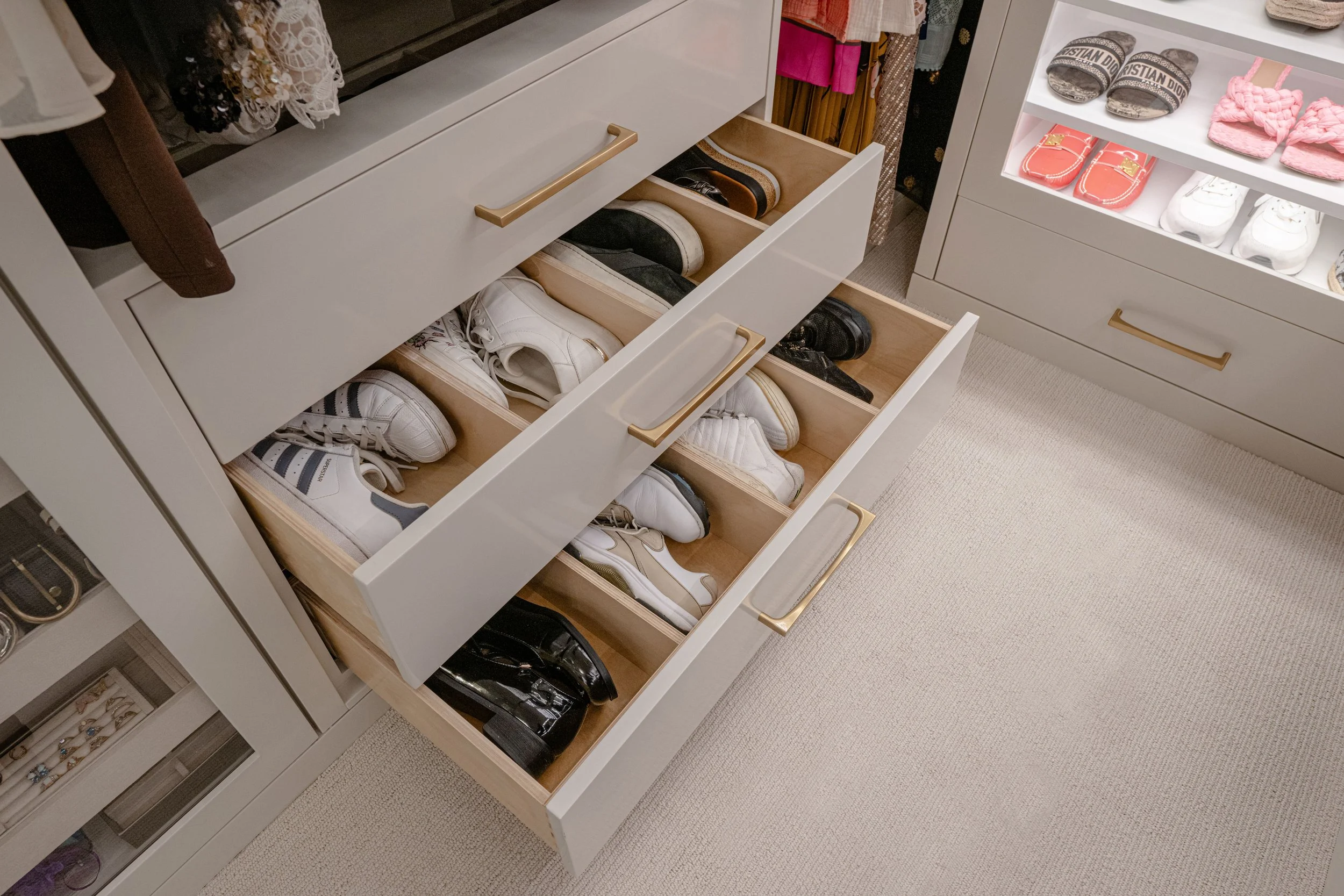 Custom closet drawers with organized sneaker storage.