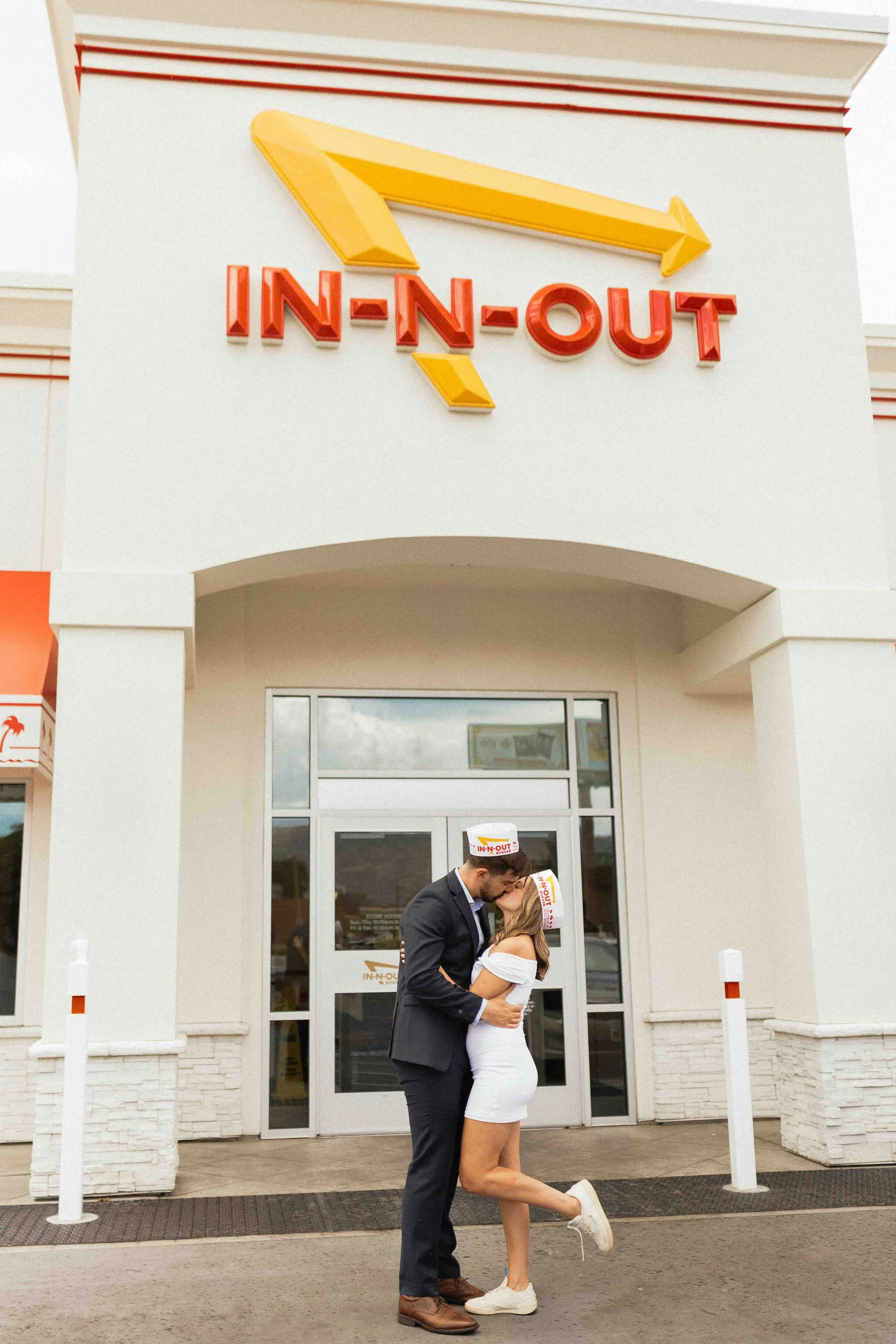 Bride and groom kissing in front of an In N Out Burger joint sign.