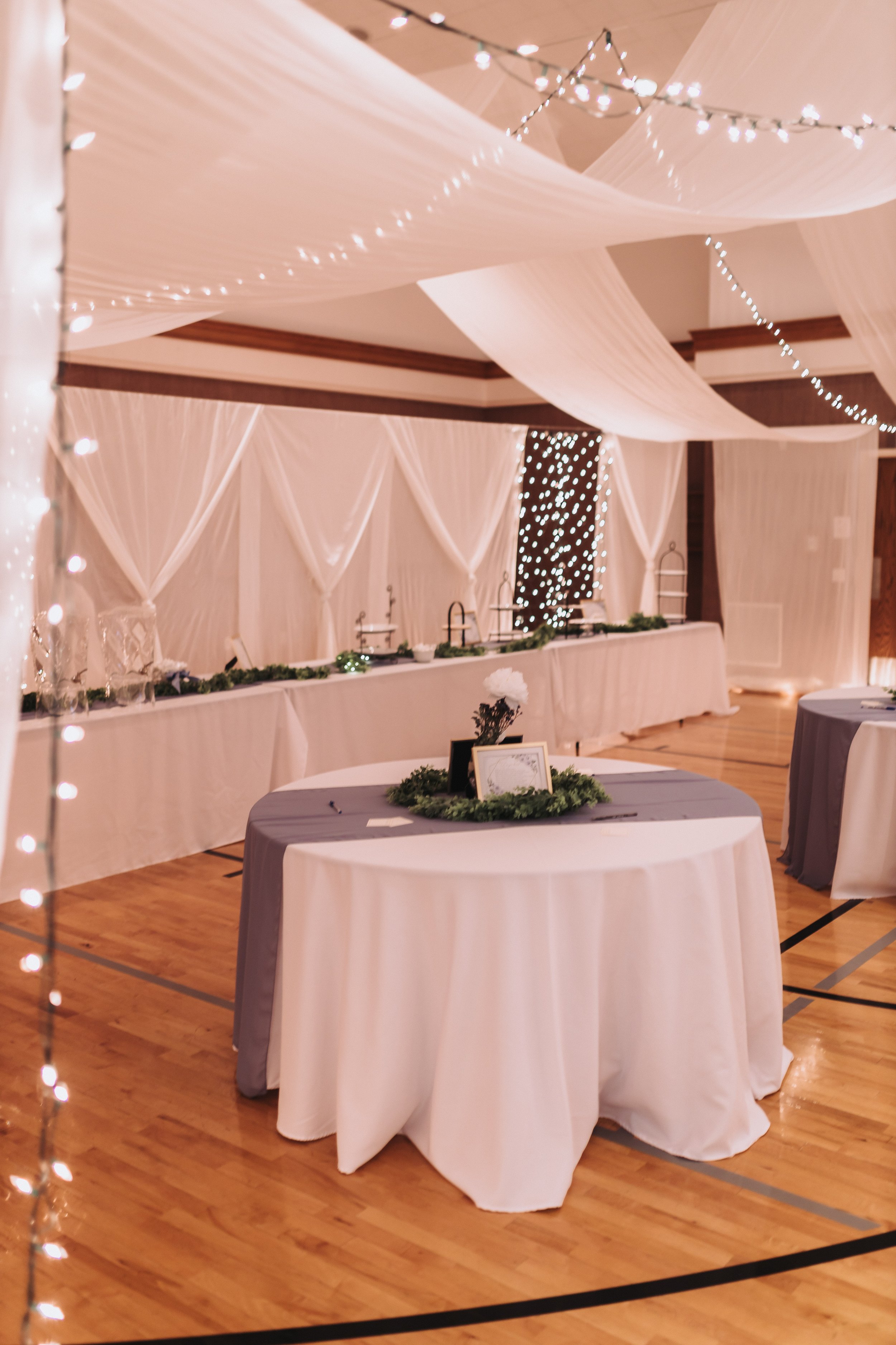 Table set up on gym floor with blue runner
