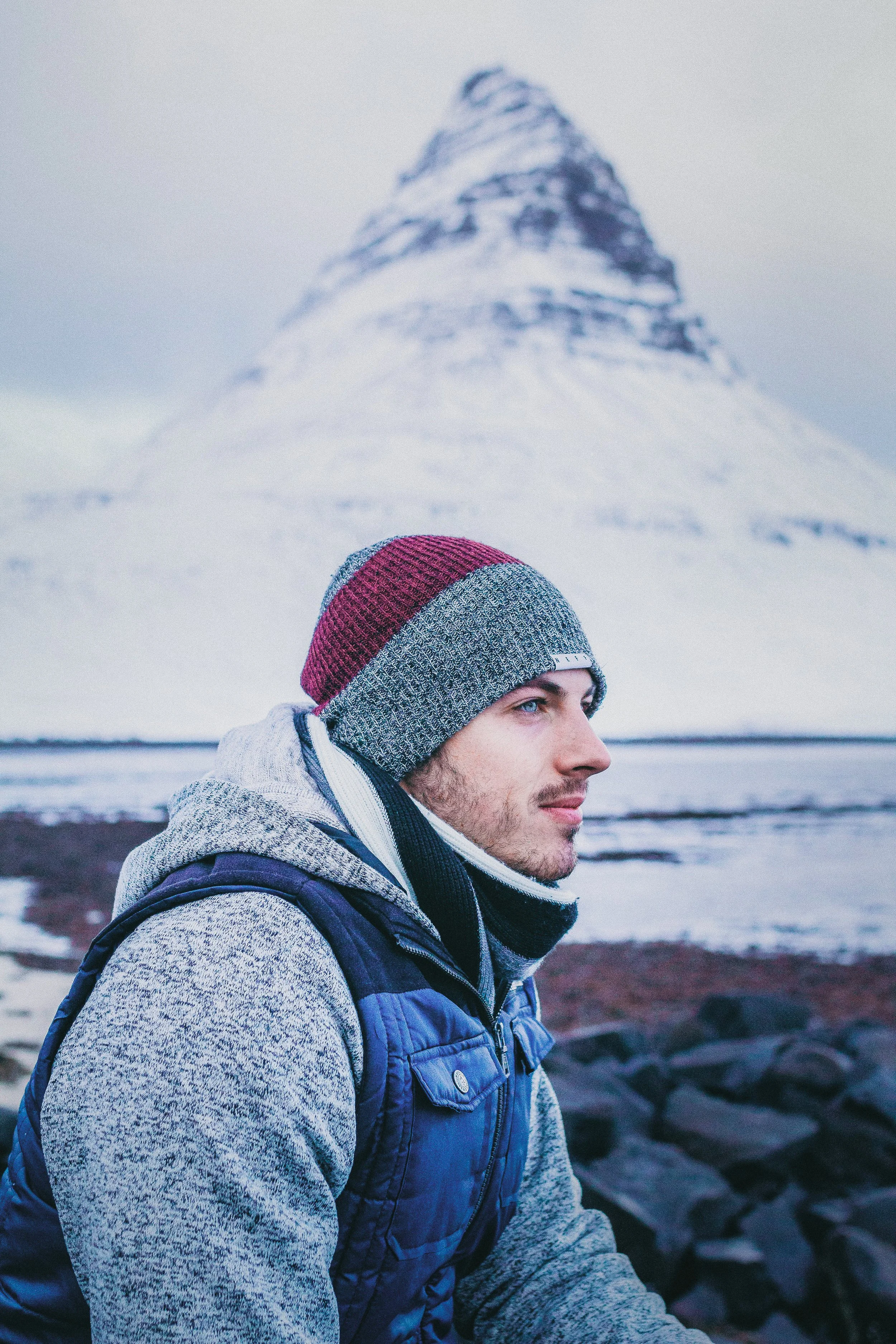 A man sitting looking out with a snowy mountain in the background
