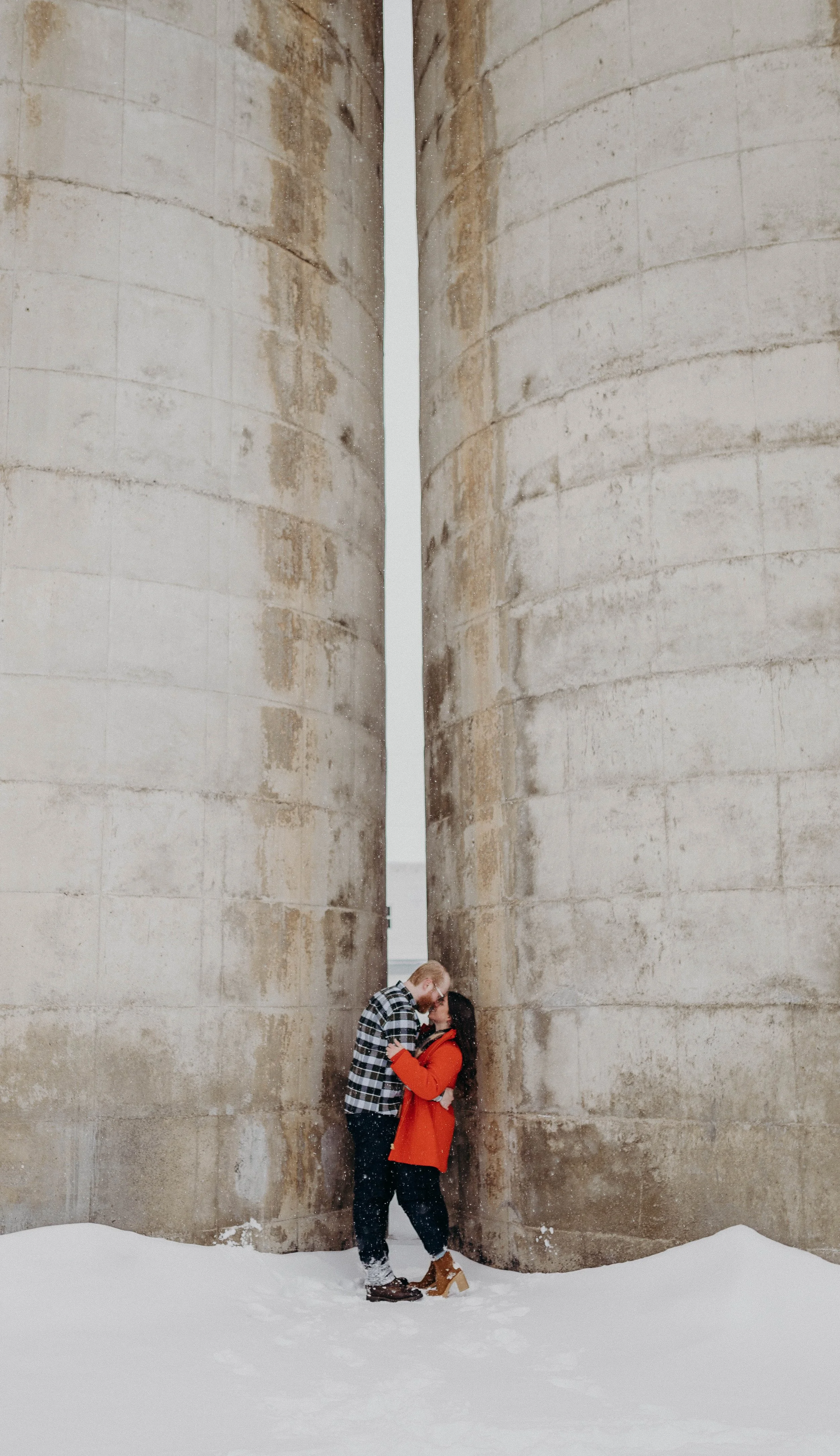 A man and woman standing forehead to forehead between two pillars