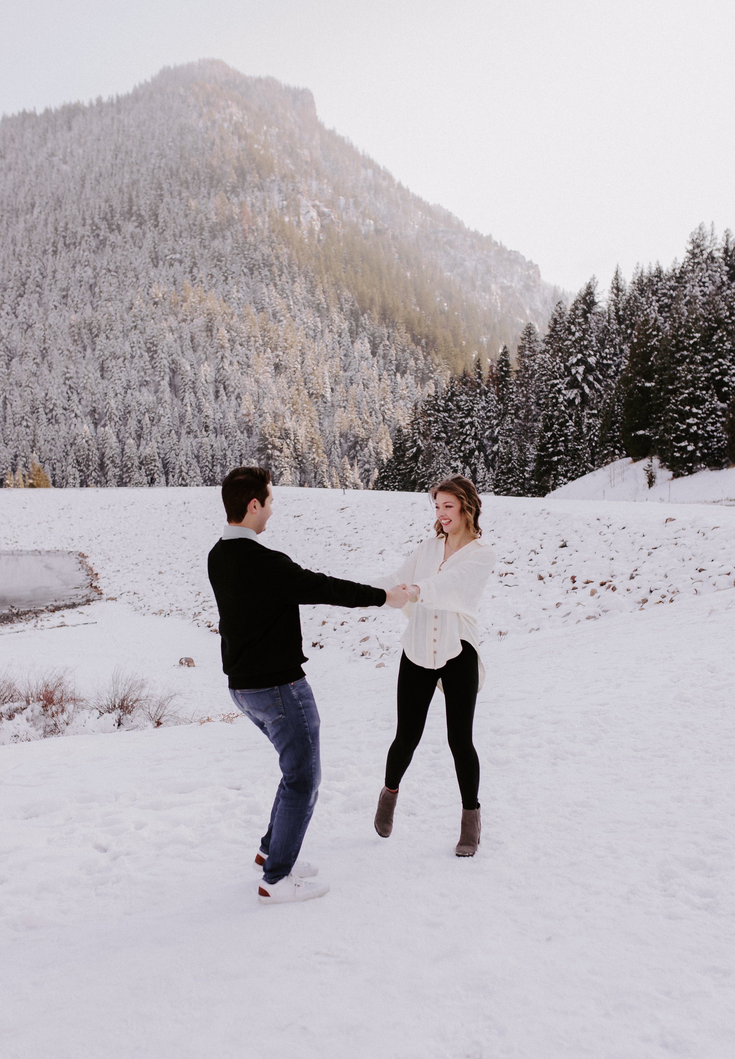 A man and woman spinning in a field of snow