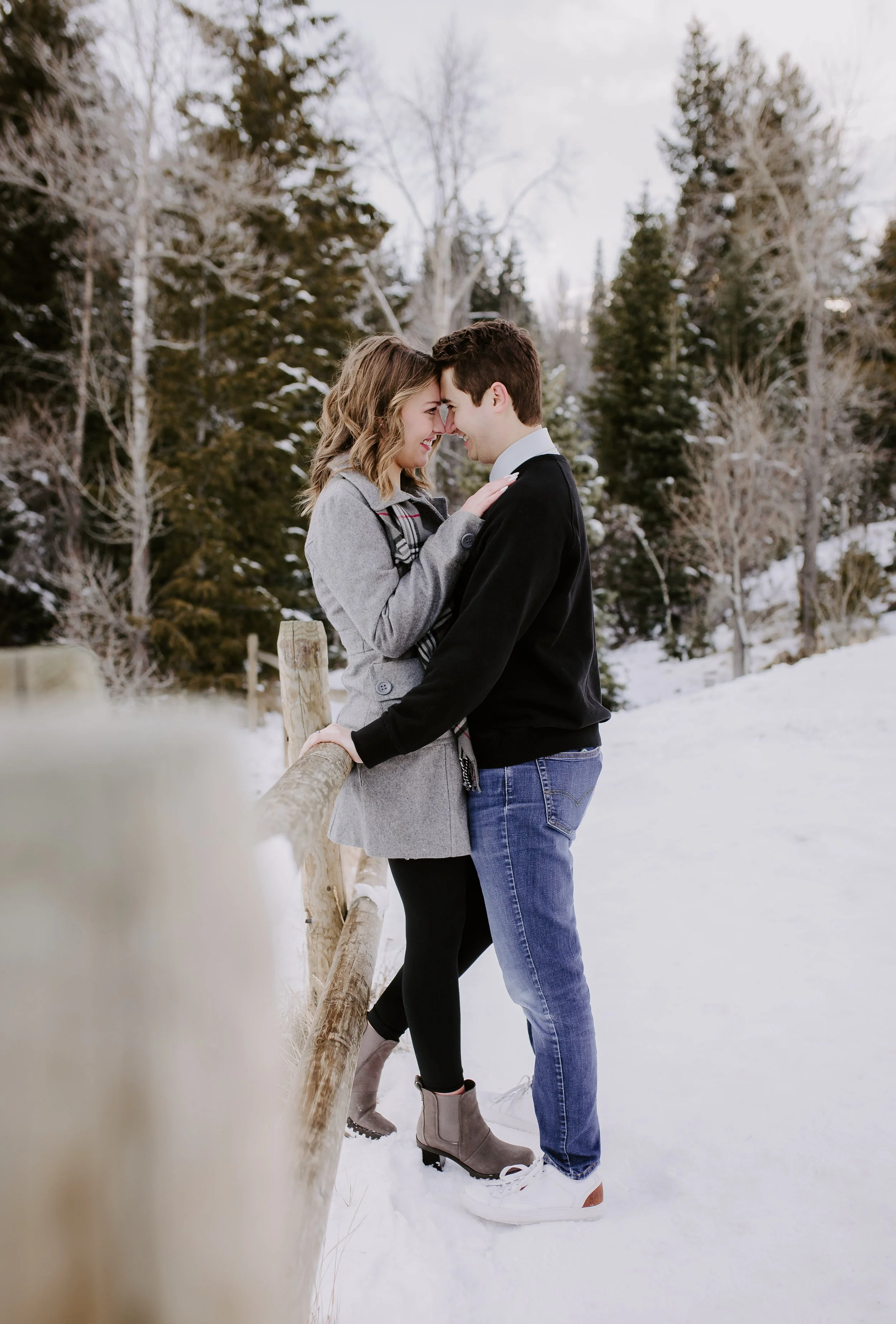 A man and woman standing forehead to forehead in a snowy field
