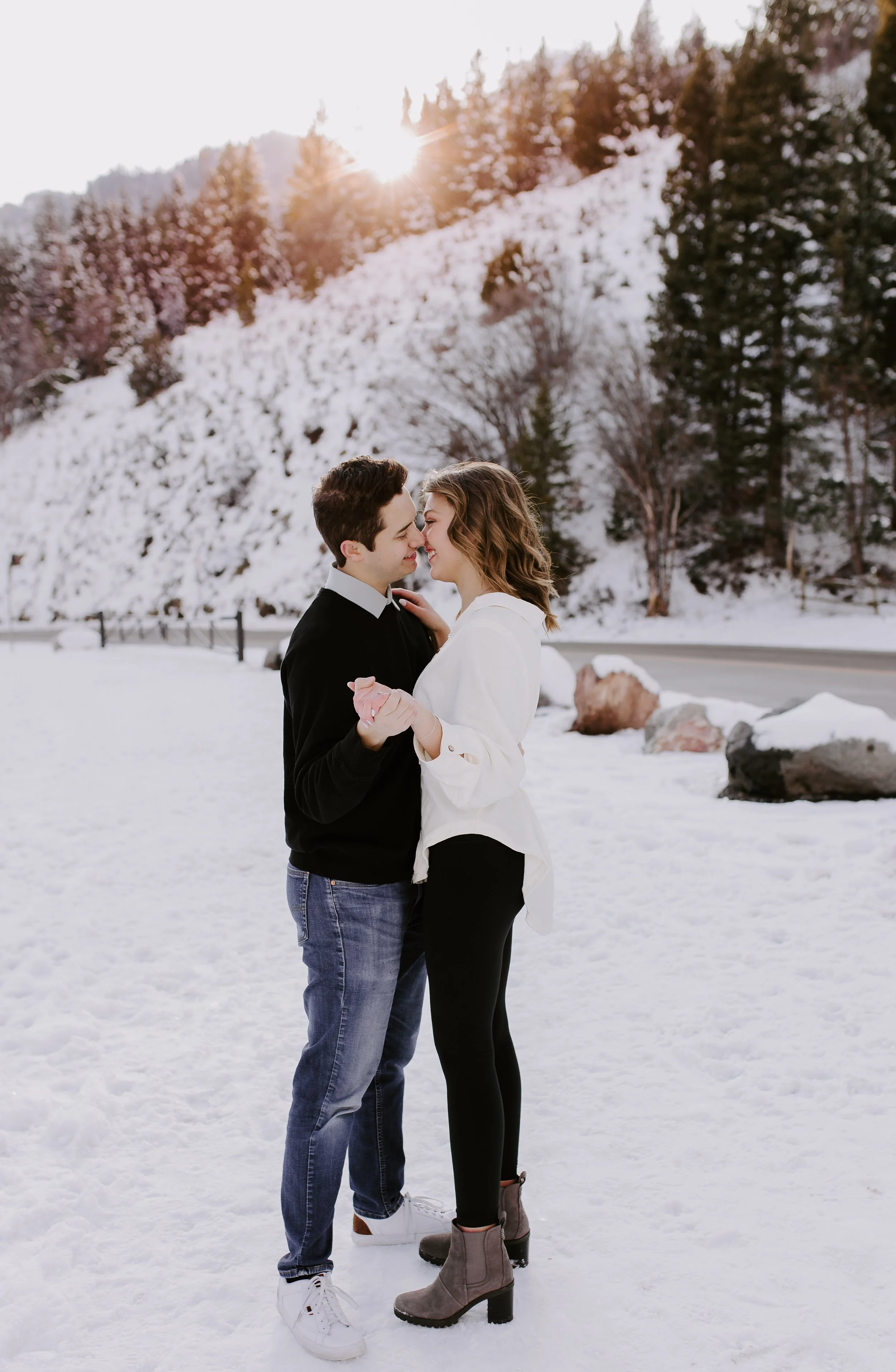 A man and woman standing and kissing in a snowy field