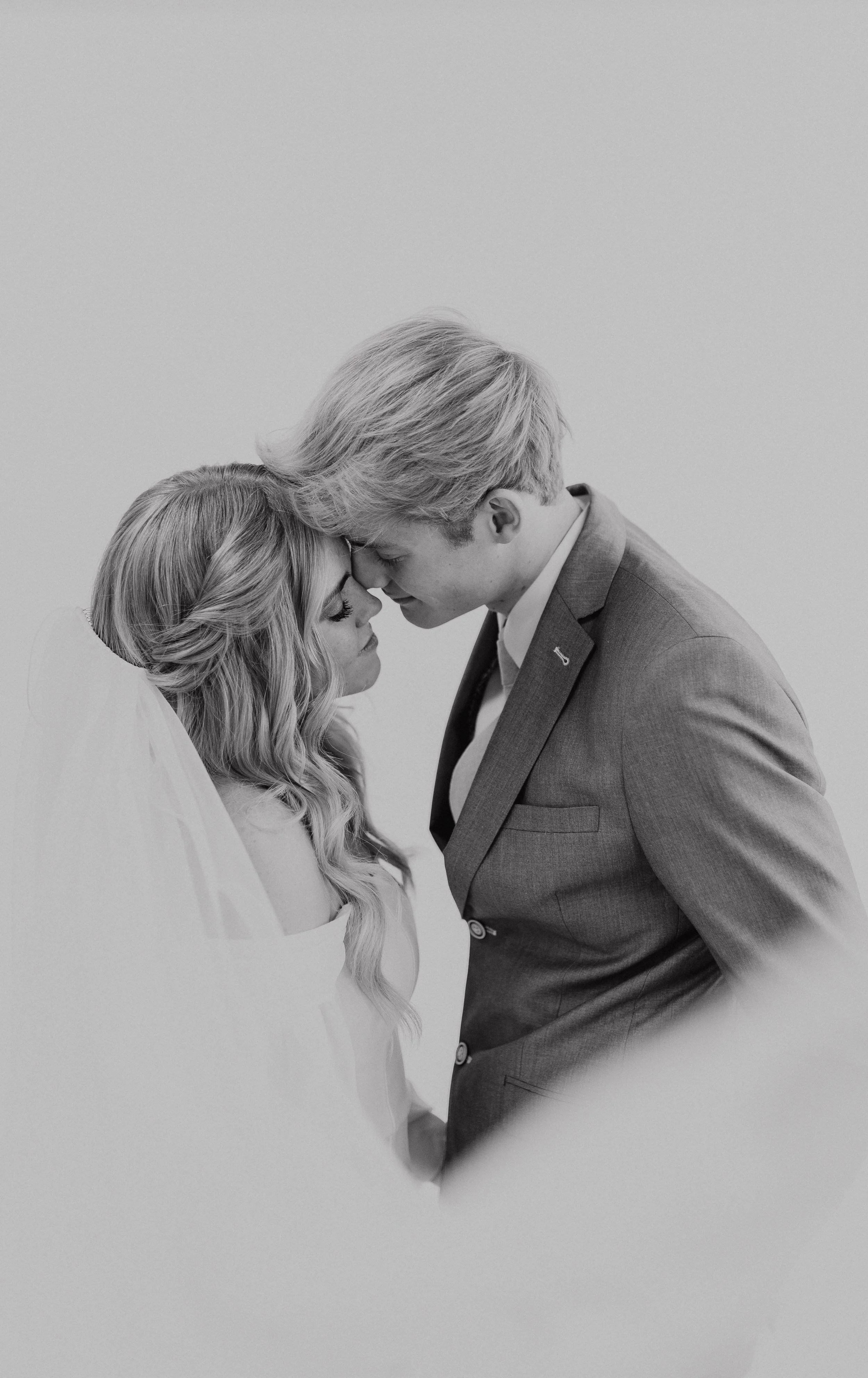 A bride and groom standing forehead to forehead