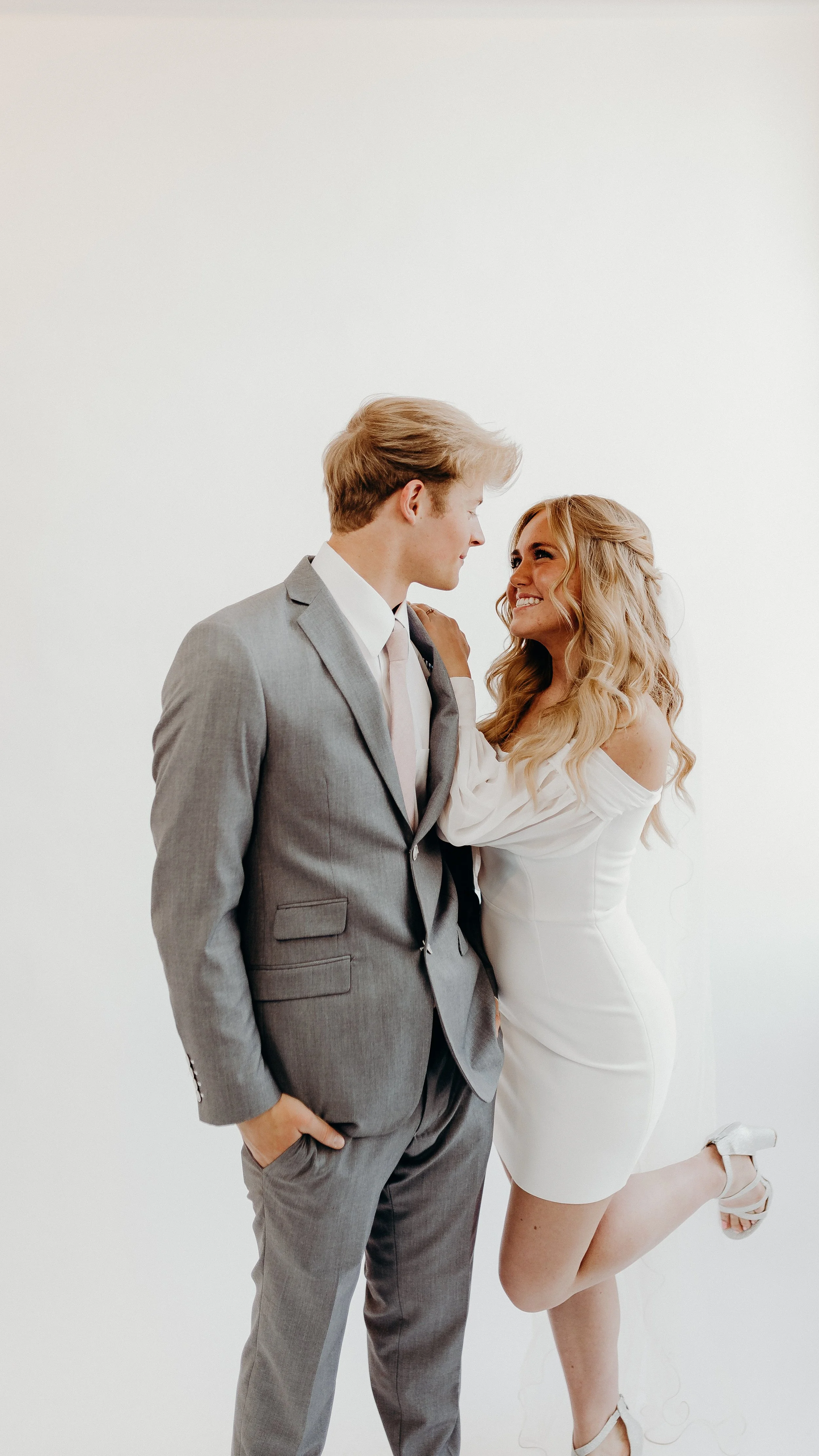 A bride and groom standing smiling at each other