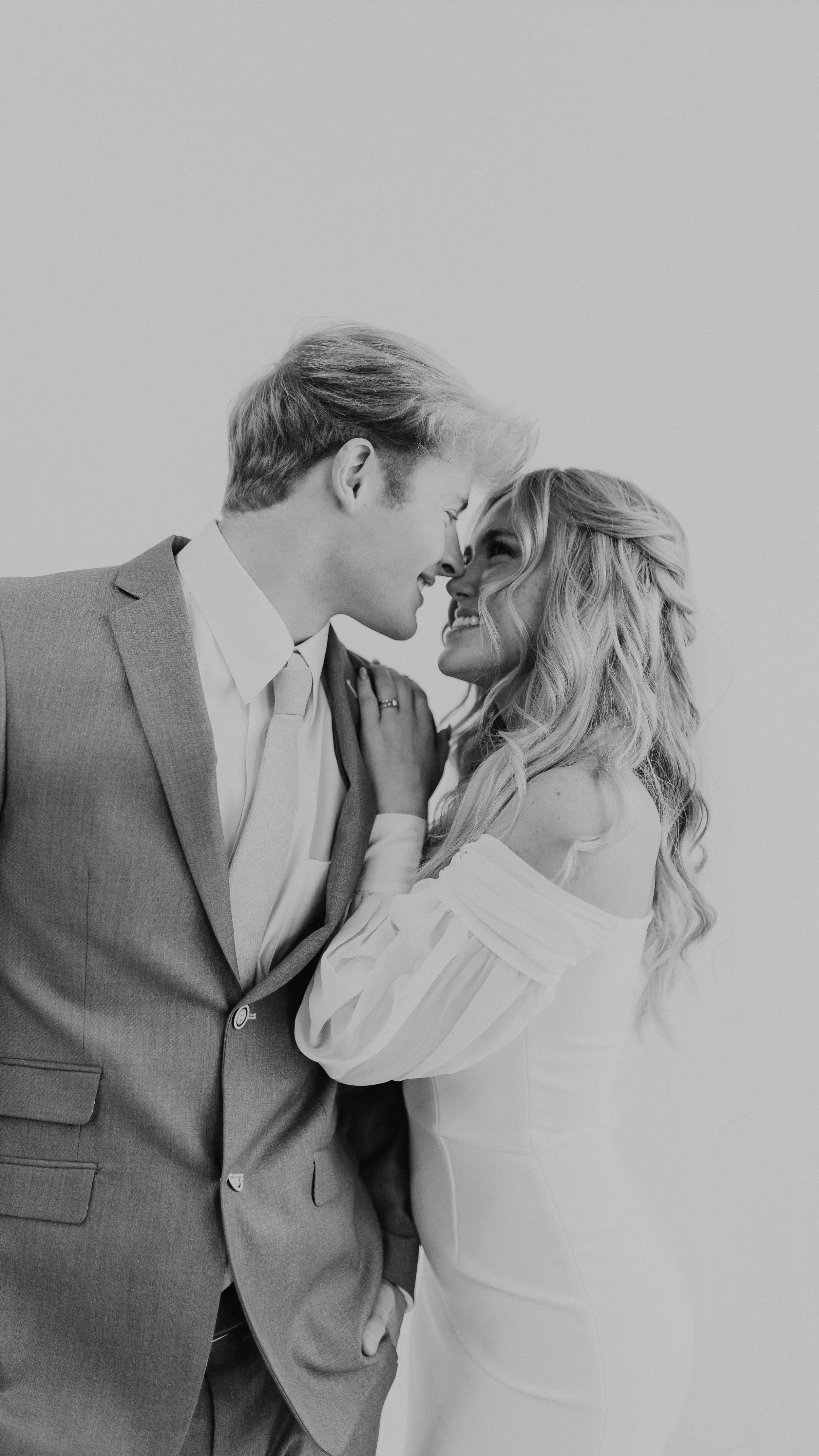 A groom and bride looking at each other smiling