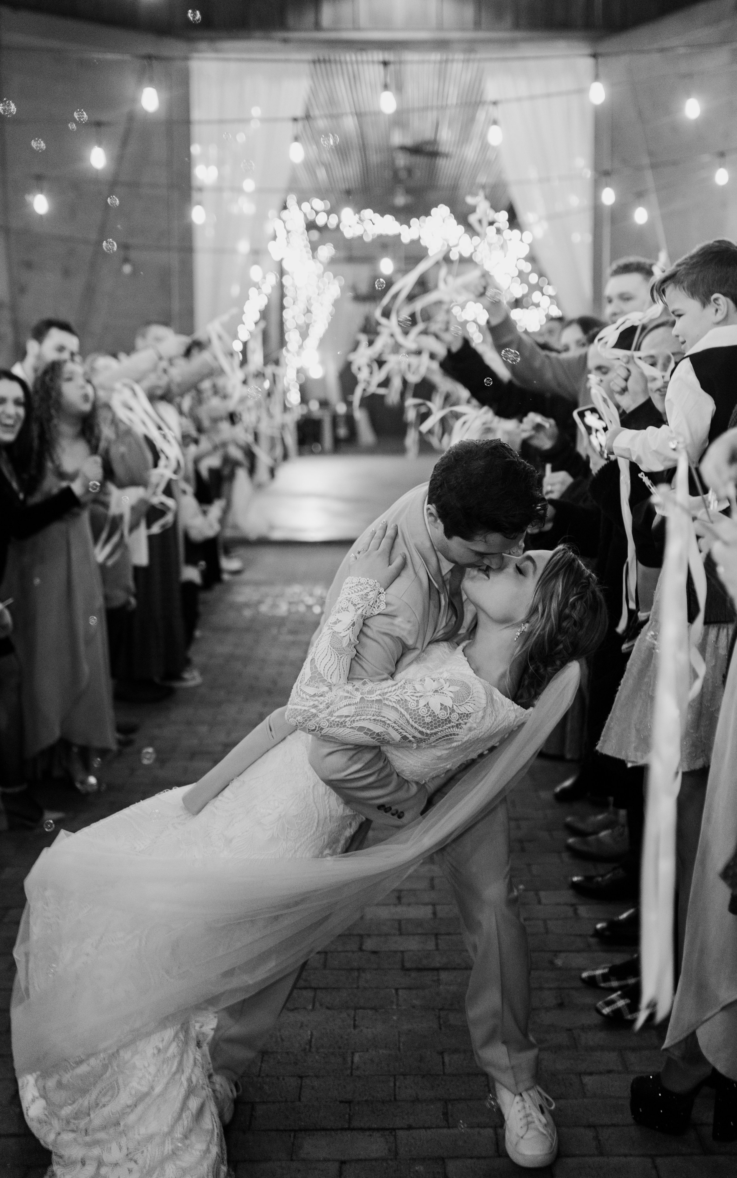 Groom dipping and kissing the bride during their wedding exit