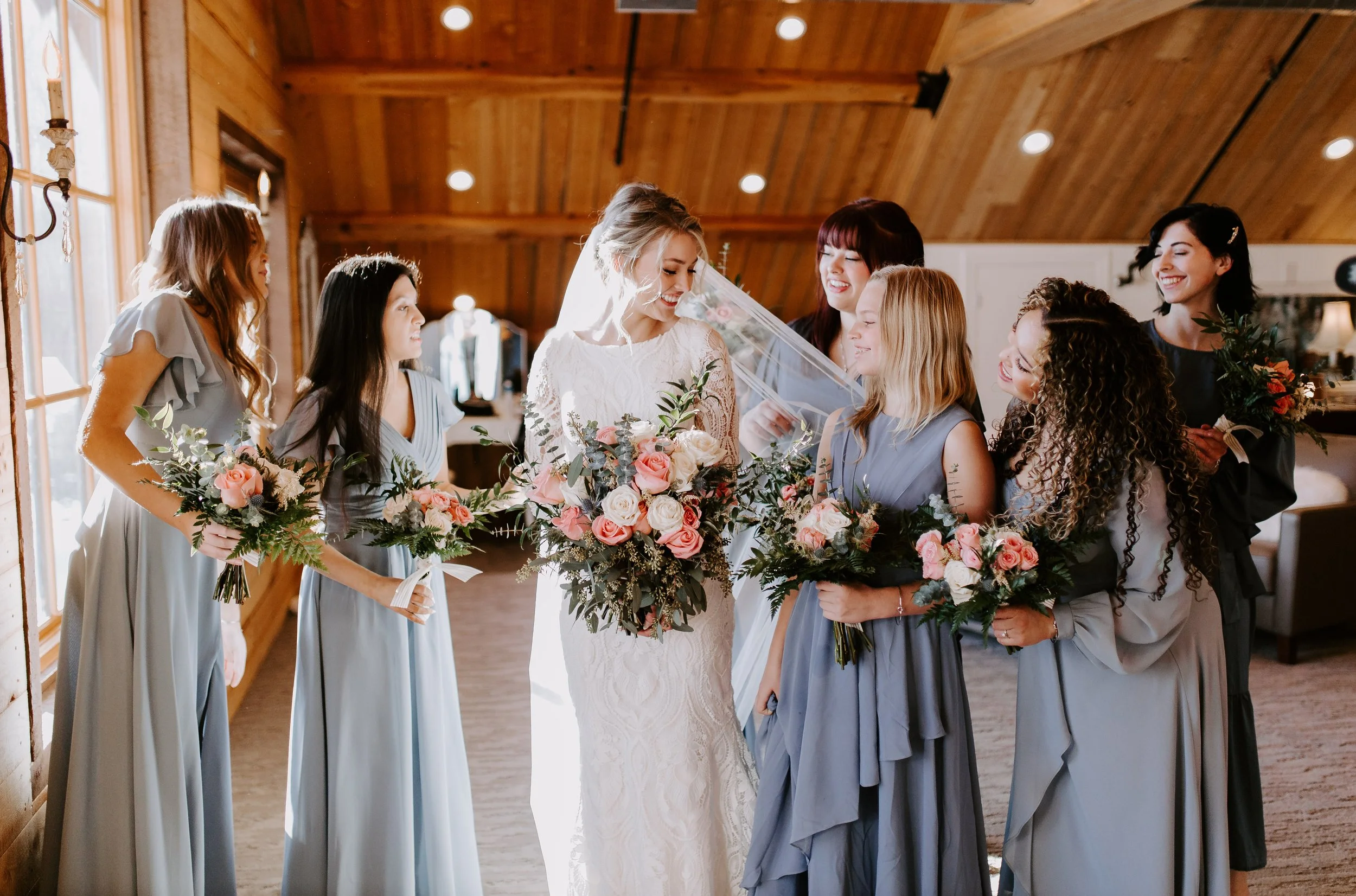 Bridesmaids in blue, looking at the bride and smiling