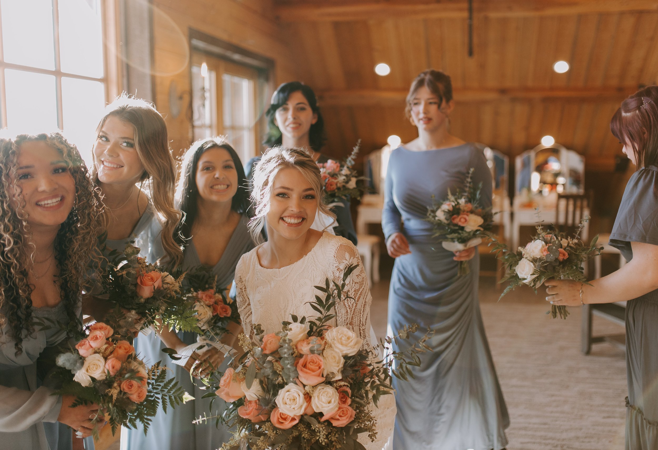 Bridesmaids in blue in the getting ready room with bride