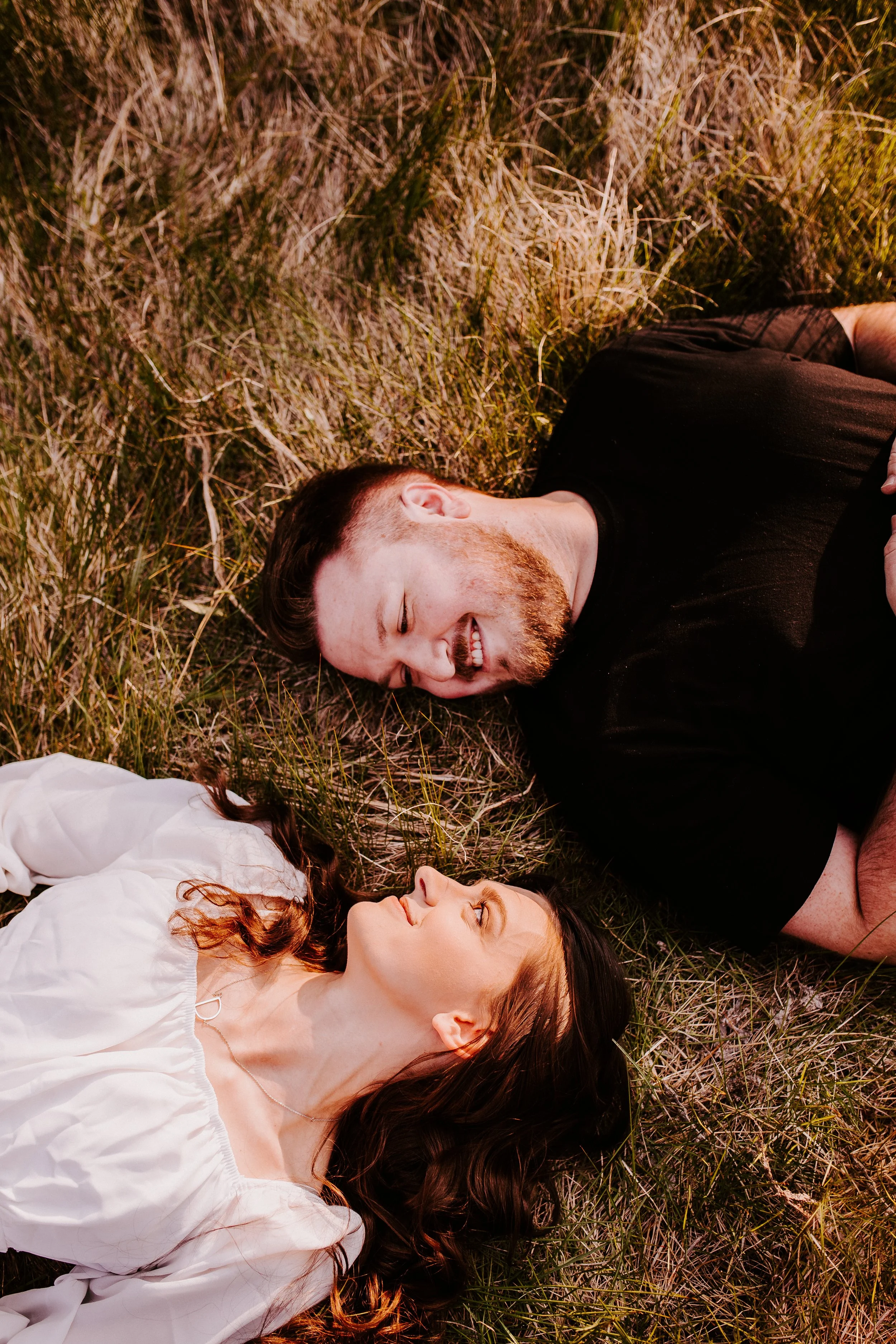 Couple laying in grass during golden hour