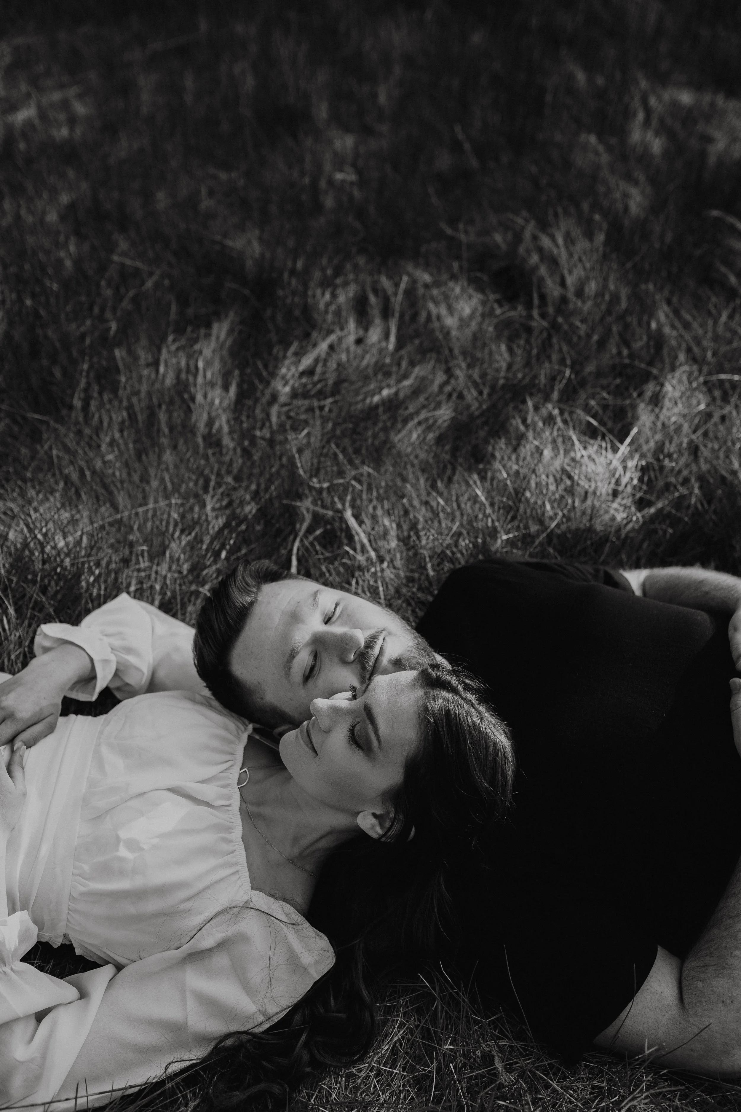 Couple laying in grass during golden hour