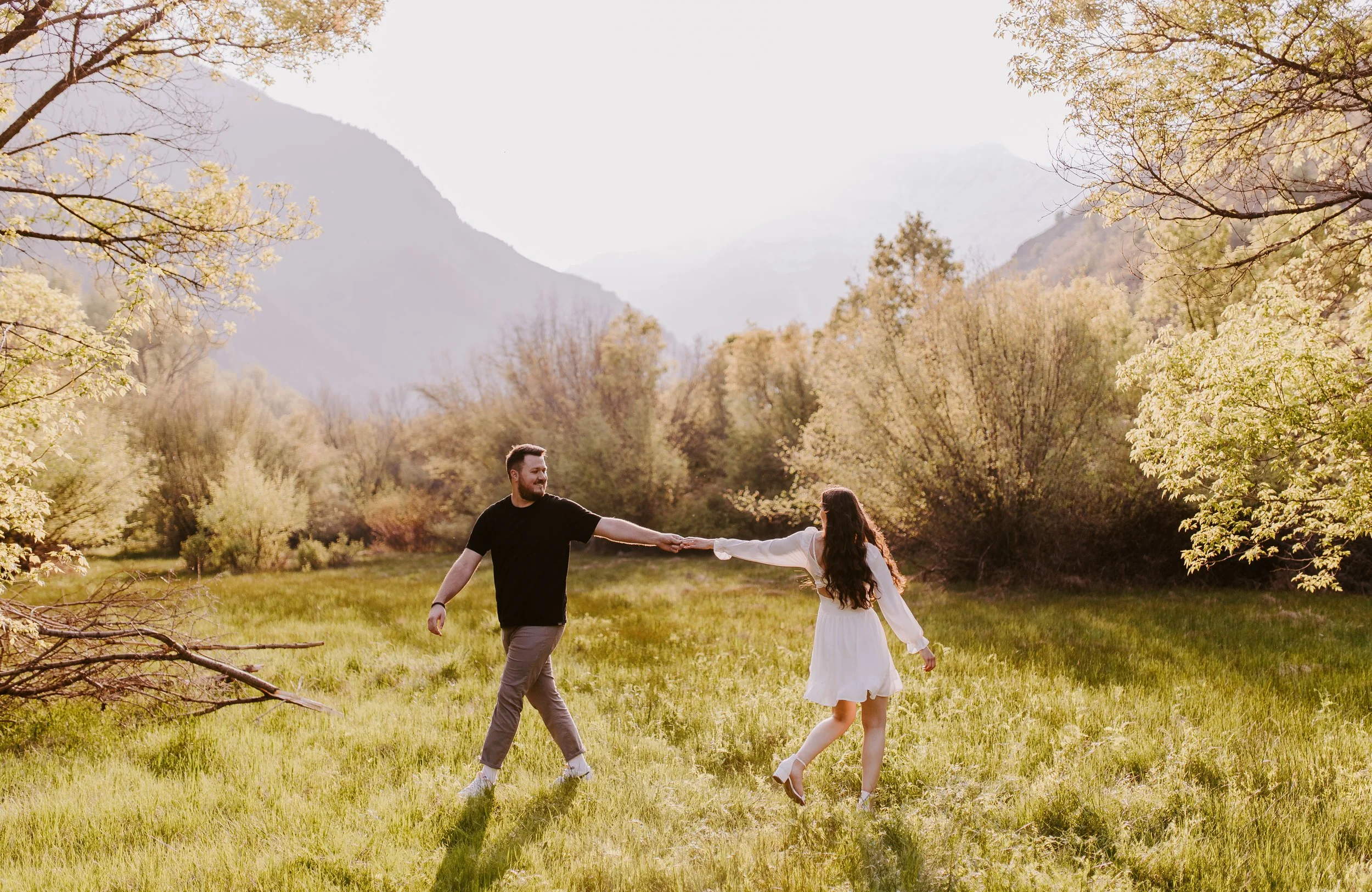 Couple holding hands in grassy field