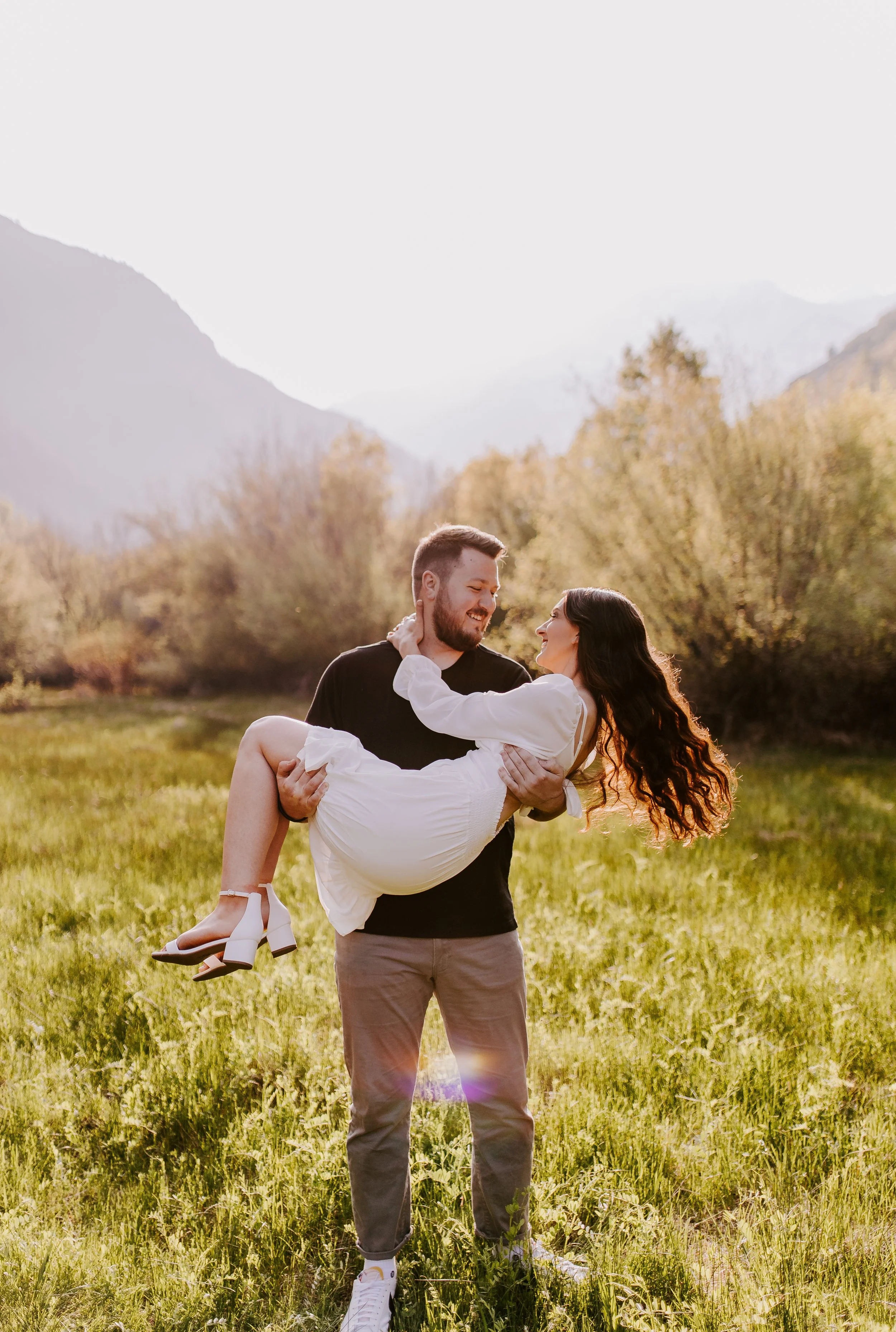 Man picking up girlfriend in a grassy field