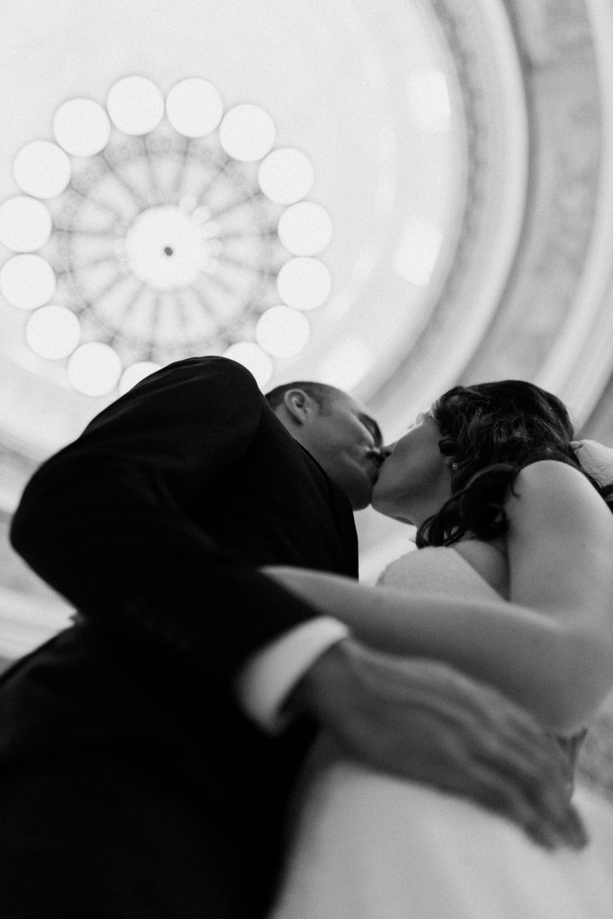Couple kissing under the Utah State Capitol Chandelier
