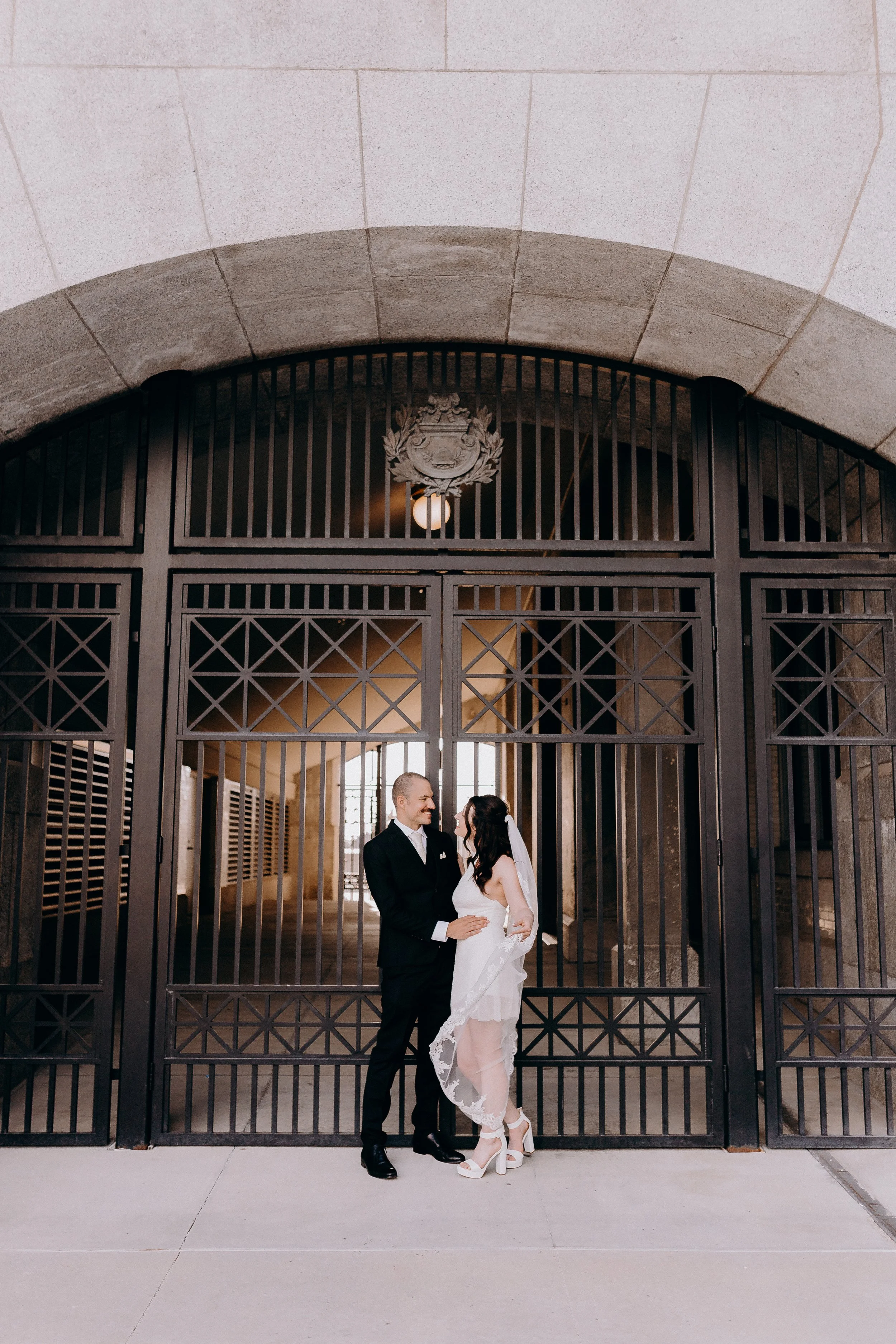 Couple embracing in front of black gate