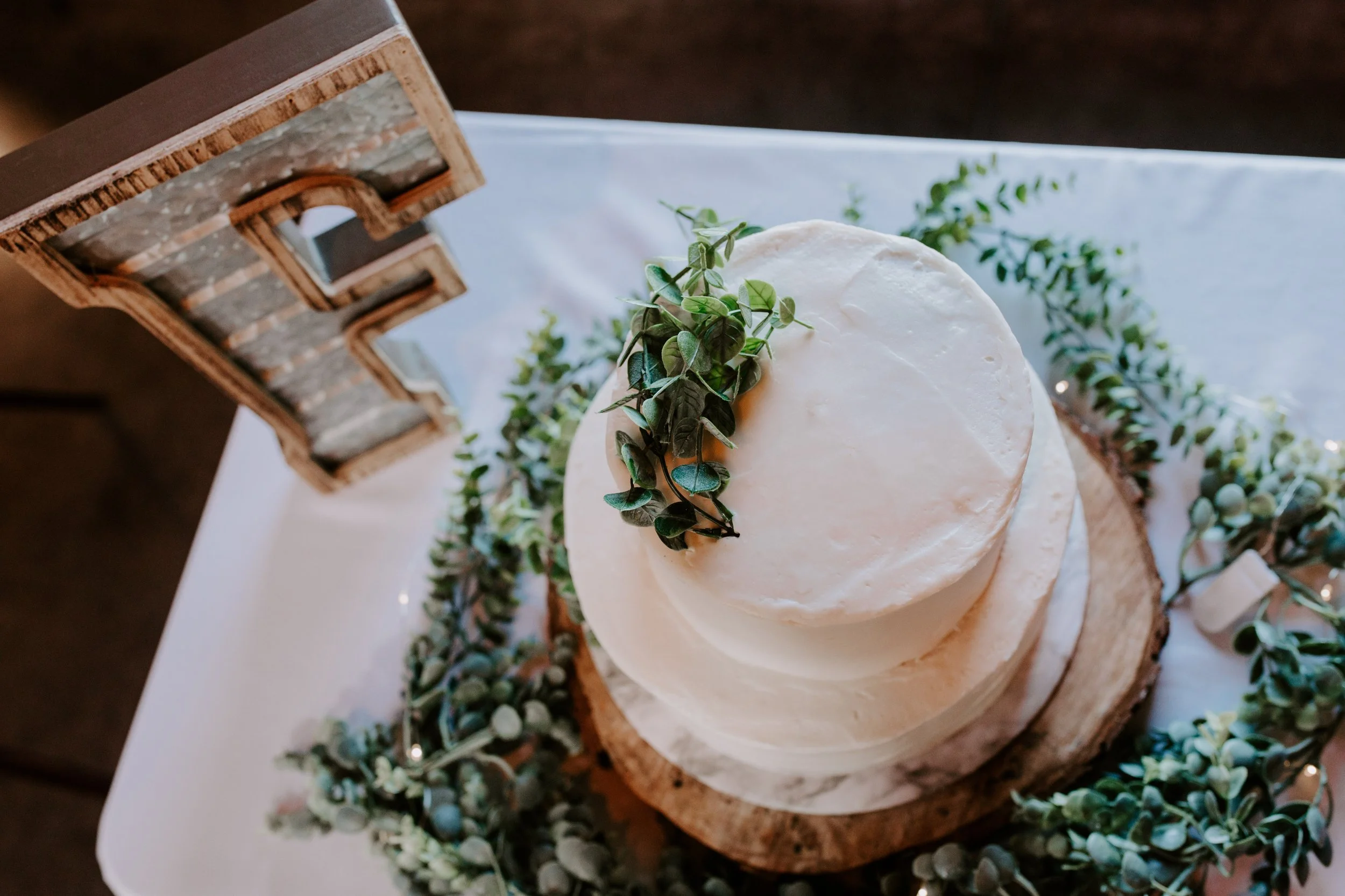 White cake with greenery on it