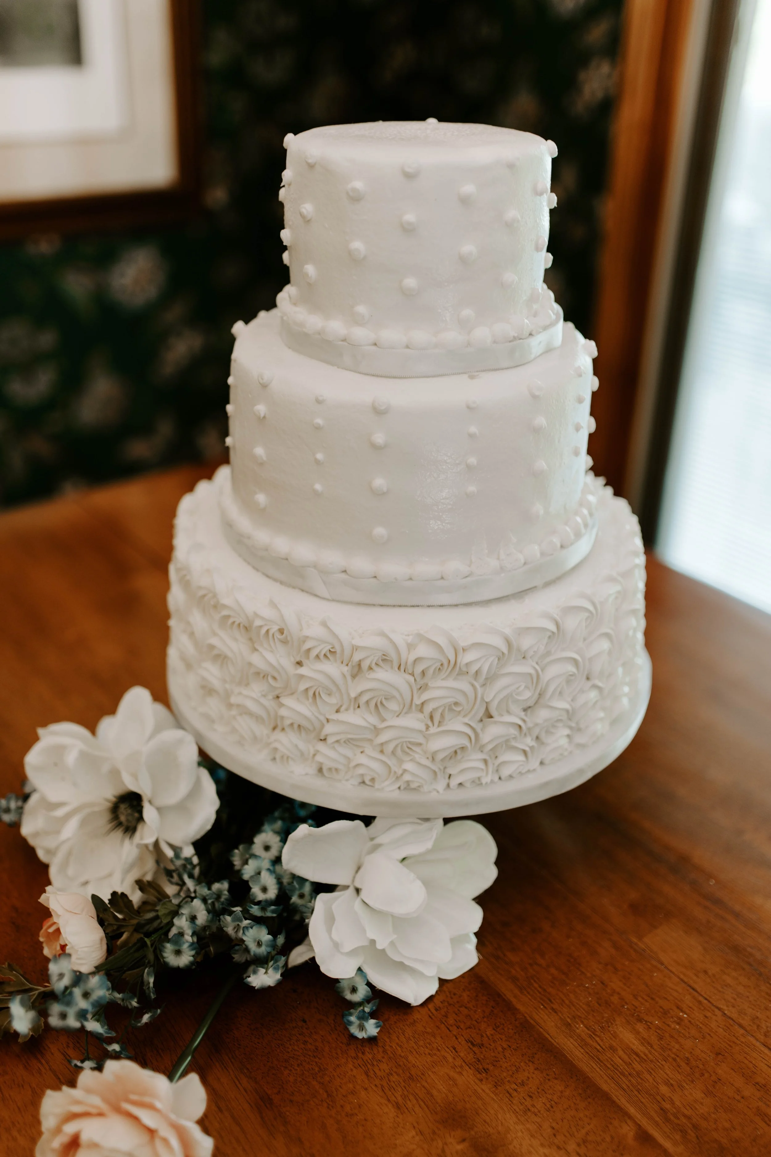 White cake with vintage style frosting on it, 3 tiers