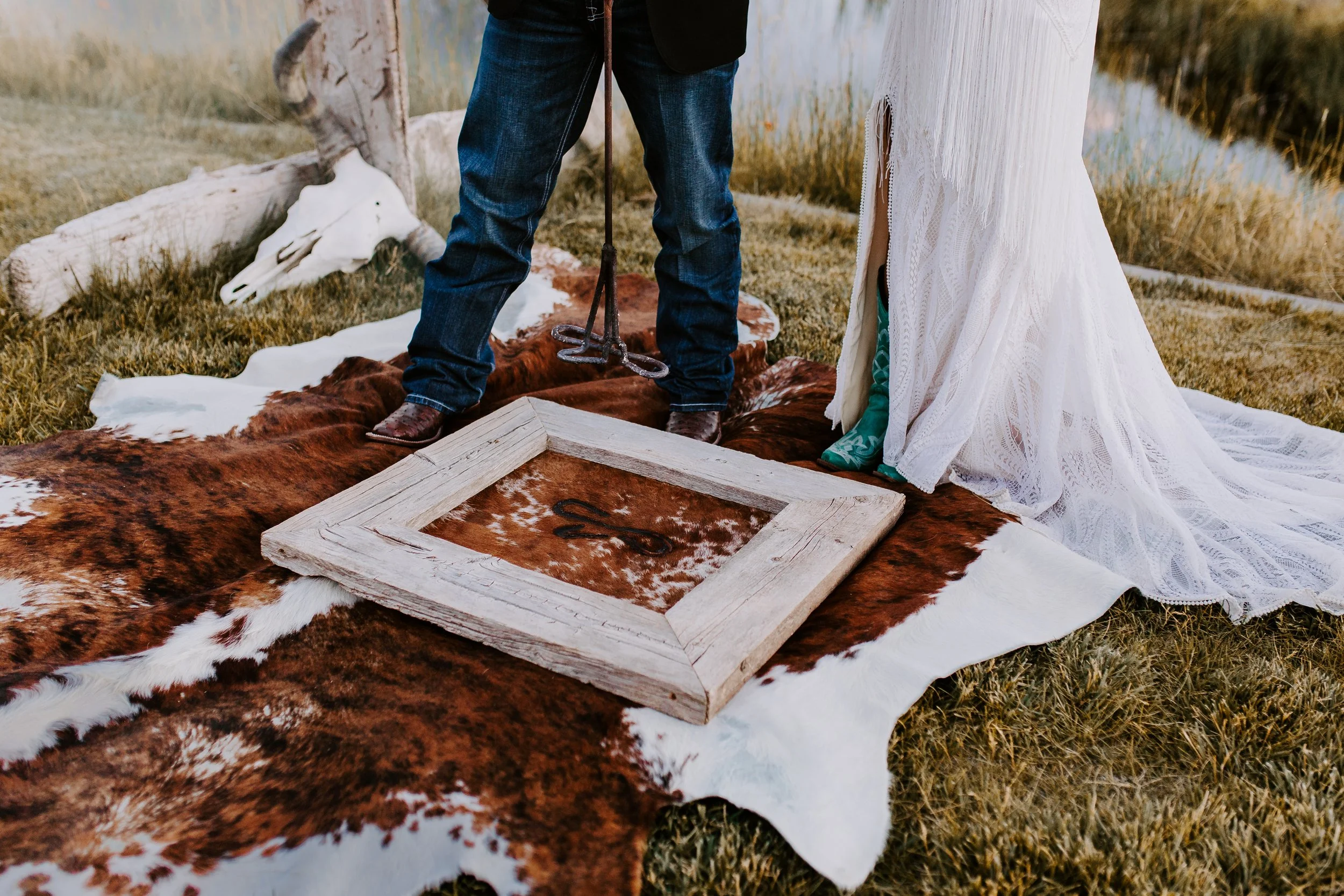 Bride and groom branding a piece of framed hide in front of an altar