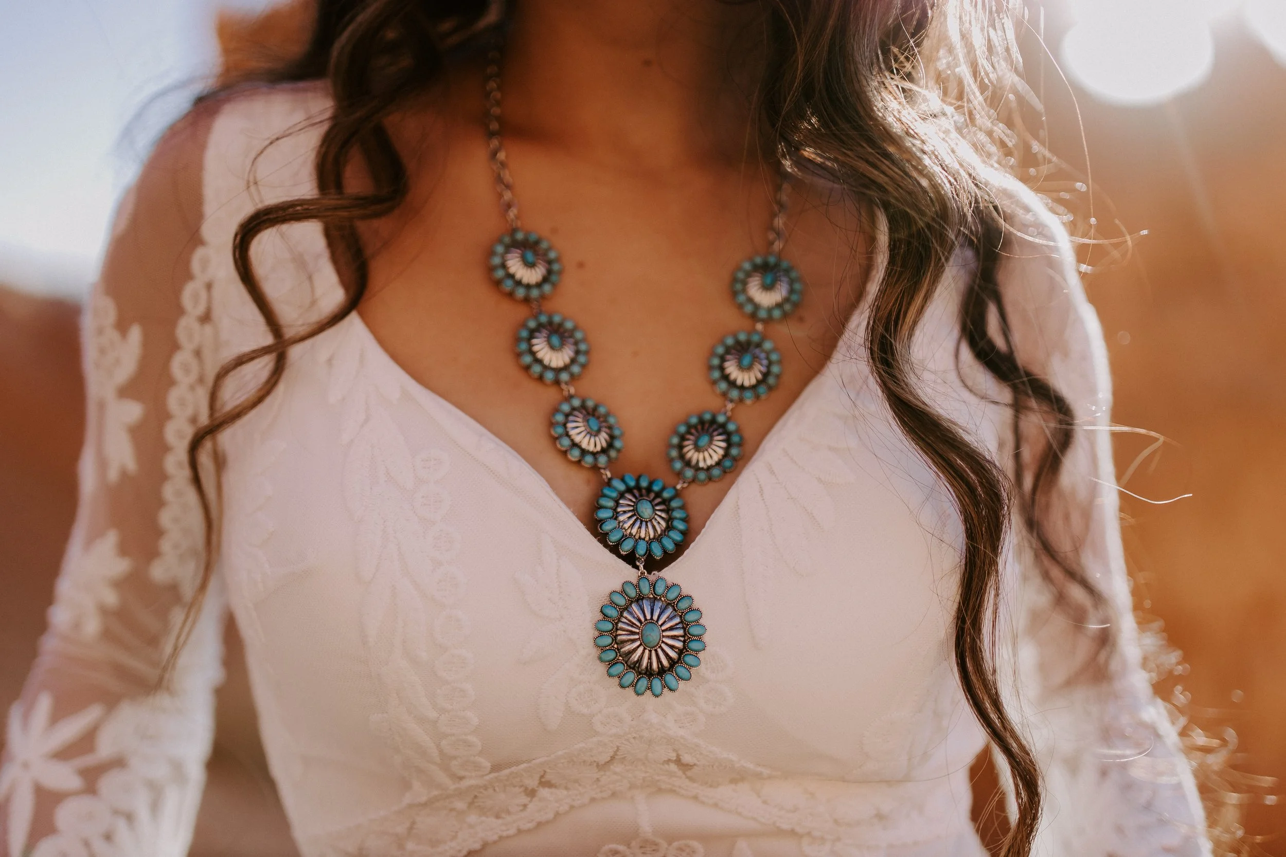 Close up of a turquoise necklace around a bride's neck