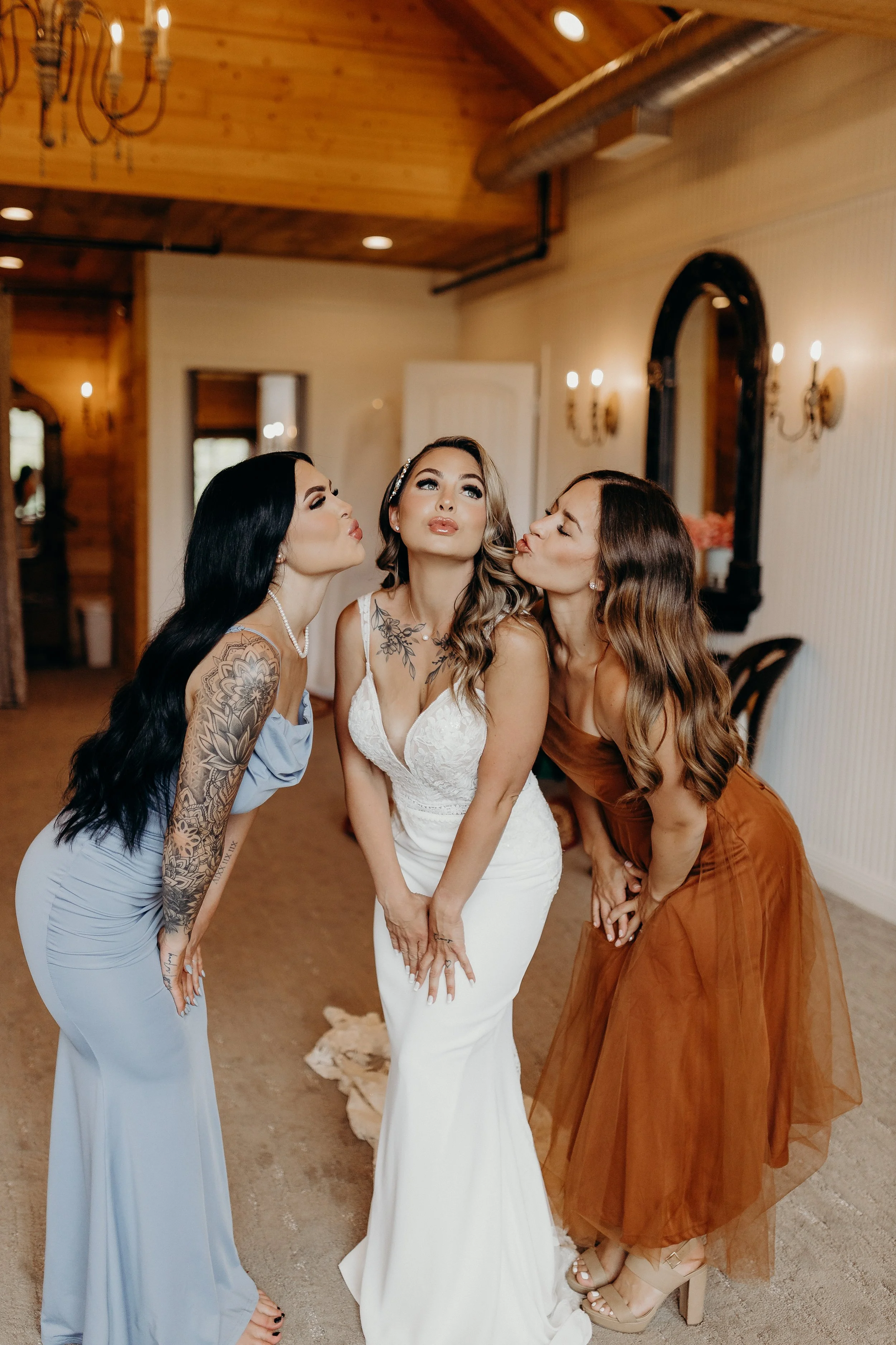 Bride with bridesmaids doing kissy faces in dressing room