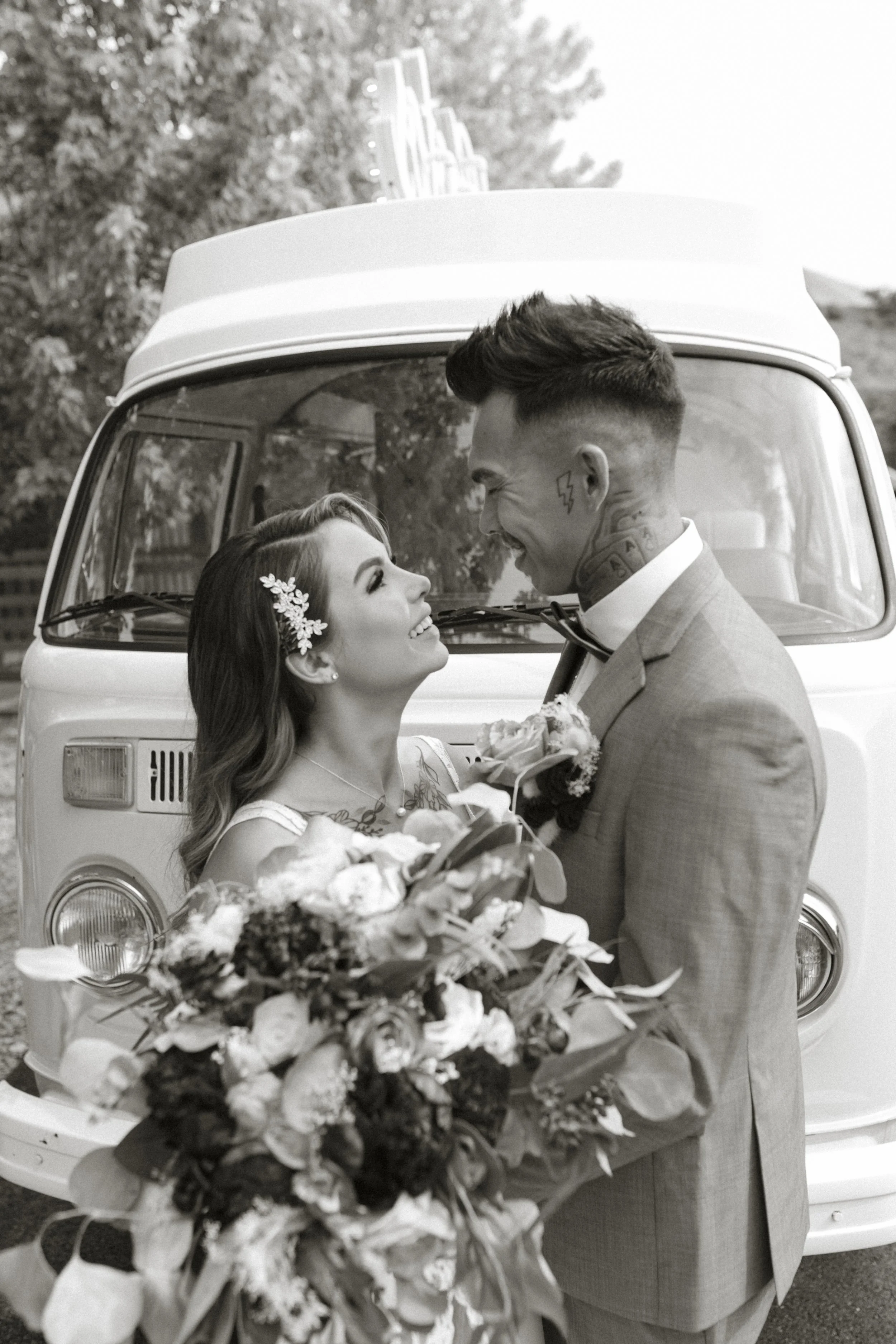 Bride and groom standing in front of Volkswagen van