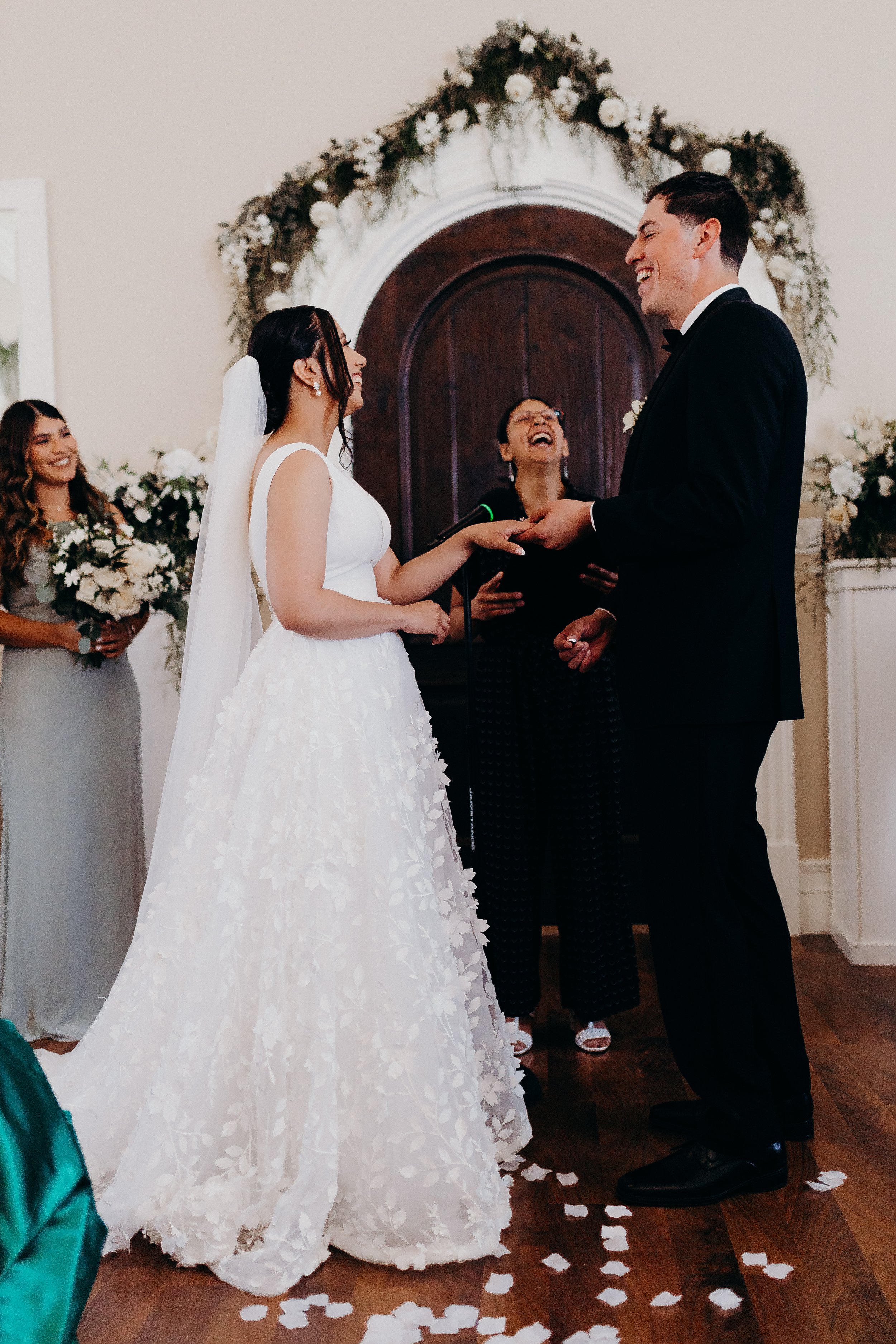 Bride and groom laughing during ceremony with officiant woman