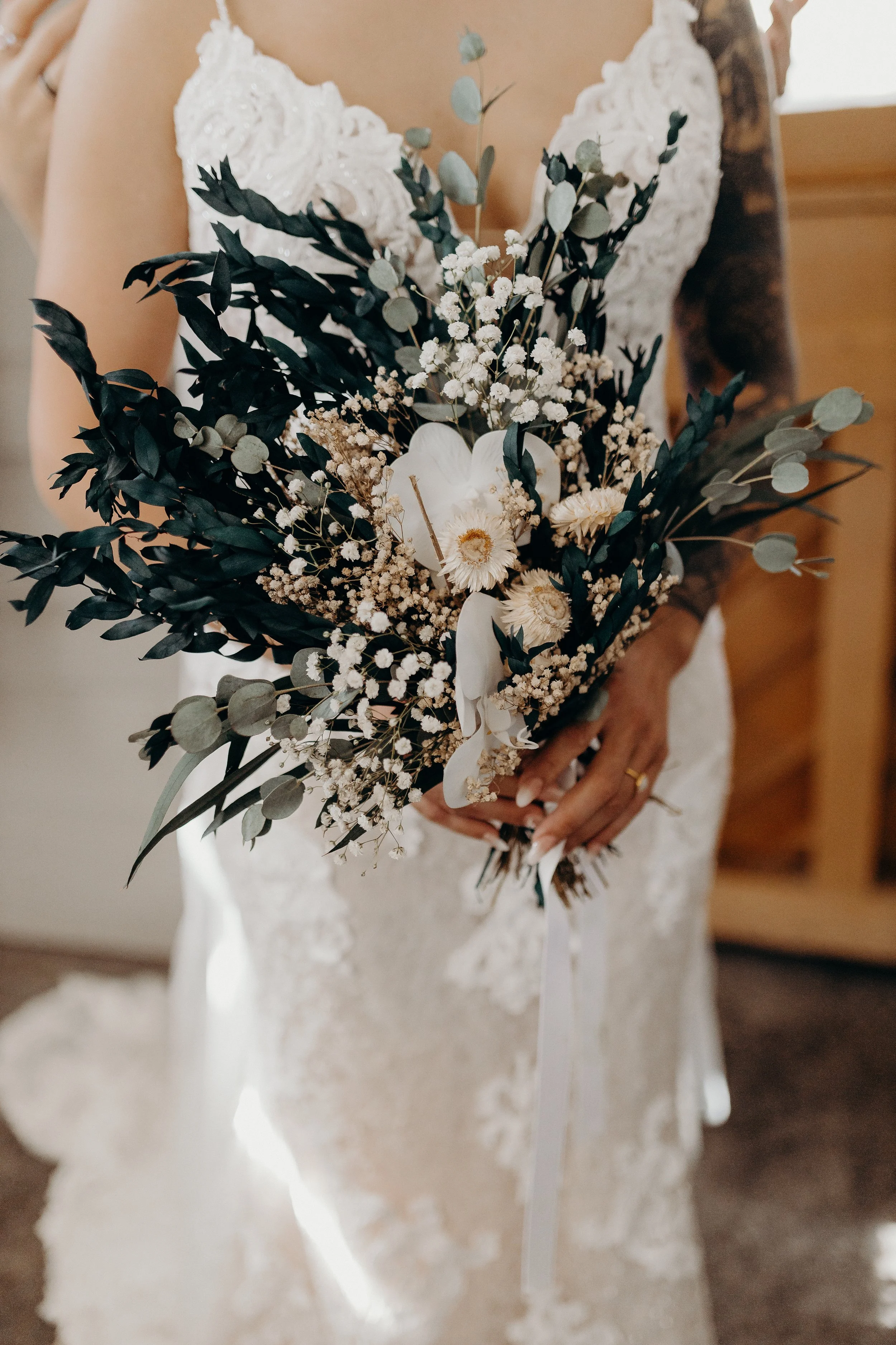 Dried flowers in front of white wedding dress
