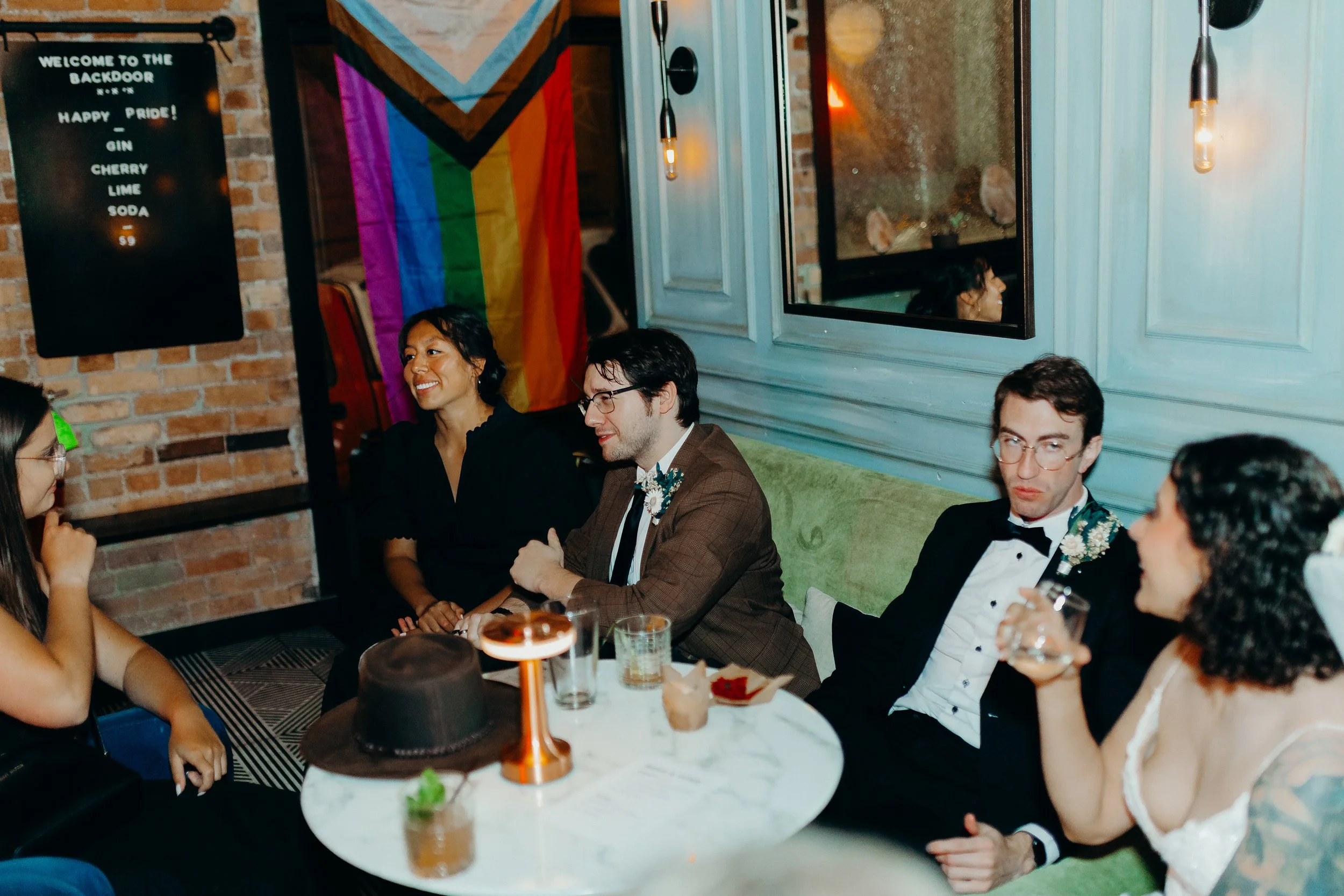 Wedding guests sitting in front of a round white table with blue walls in the background
