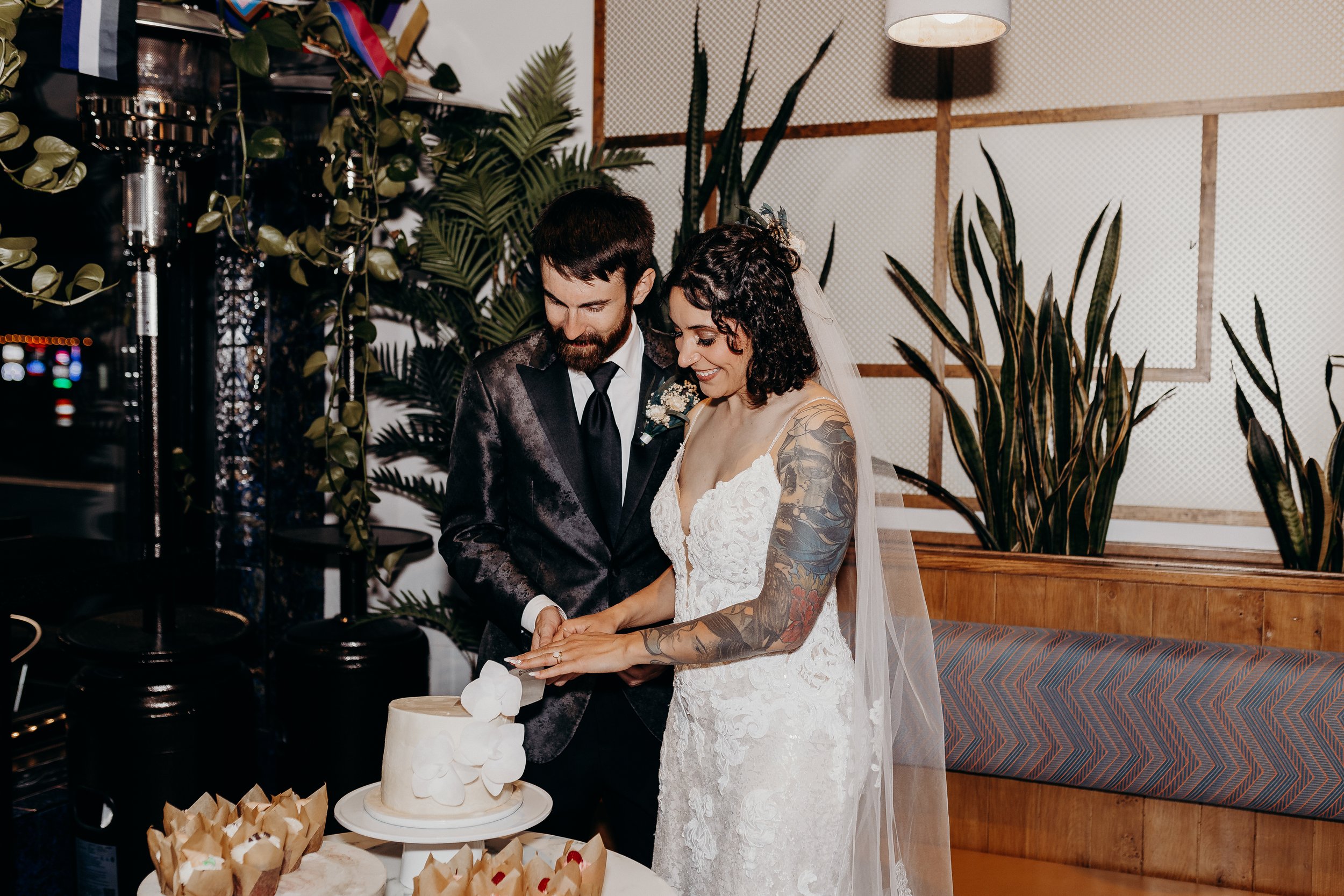 Bride and groom cutting into white cake