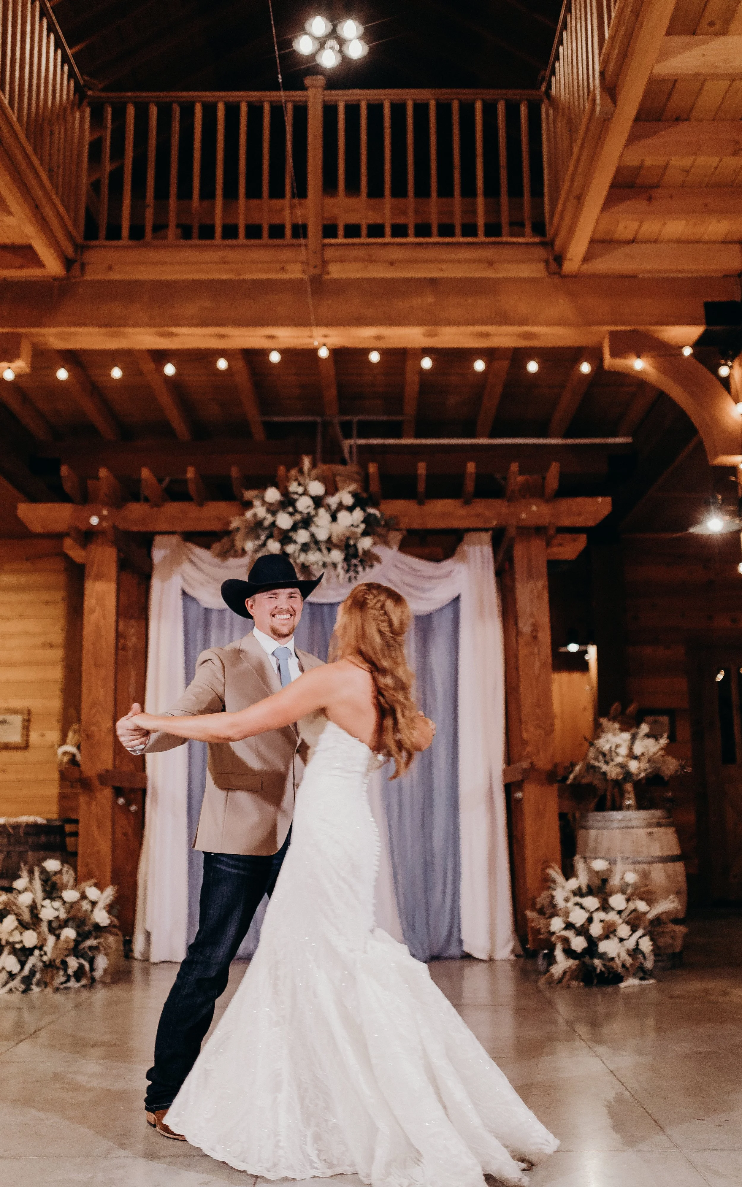 Bride and groom swing dancing in barn