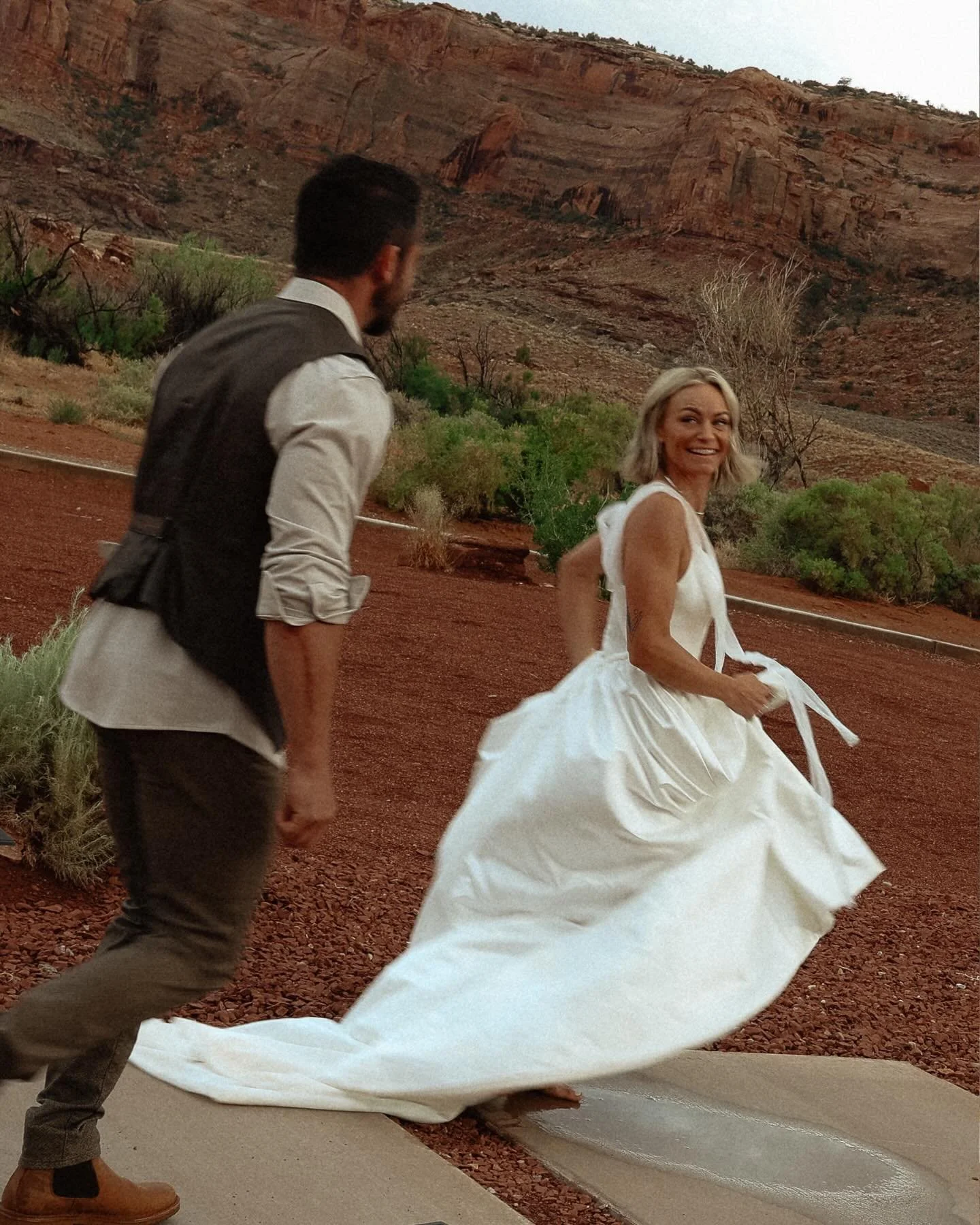 Jumping in the rain puddles after marrying you. ⛈️ 

#moabweddingphotographer #moabweddingvideographer #moabelopementphotographer #moabelopementvideographer #redearthvenue 

Venue: @theredearthvenue
Planning &amp; Design: @terravidaevents
Chairs &amp