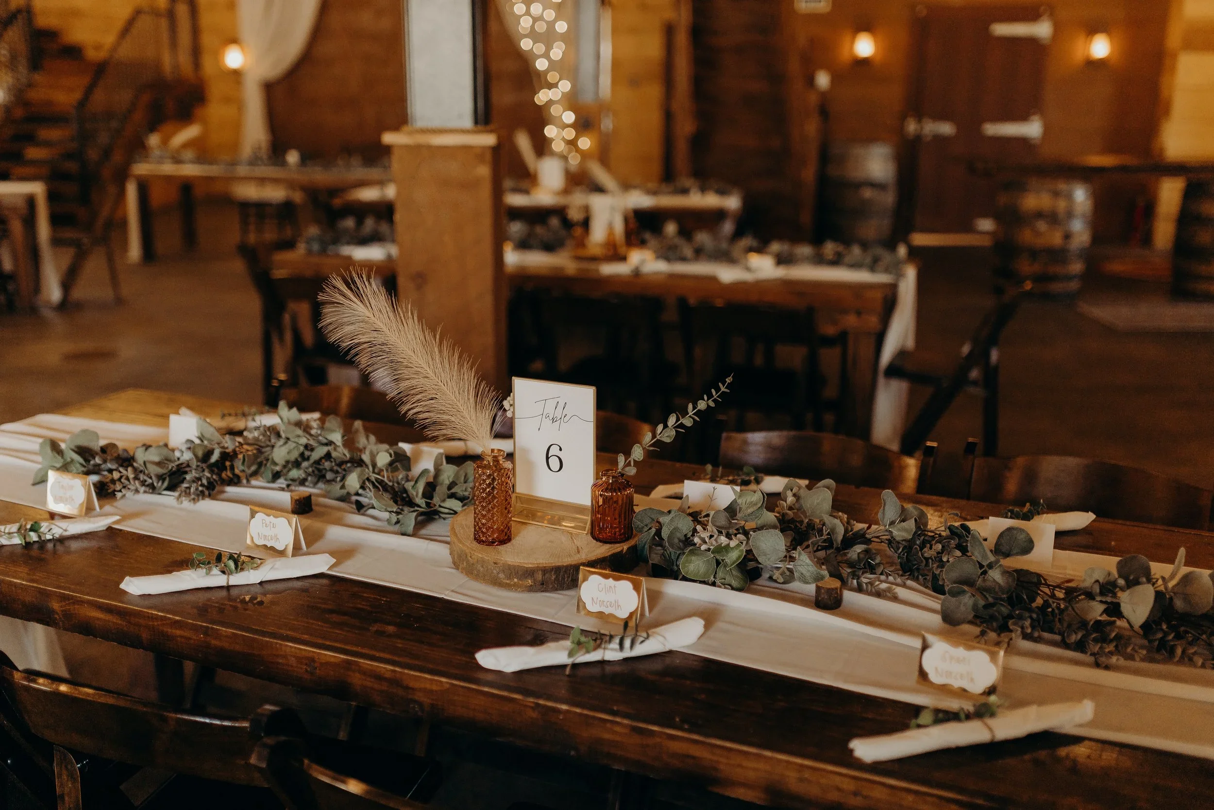 Wooden Table decorated for a wedding with a #6 on the table. 