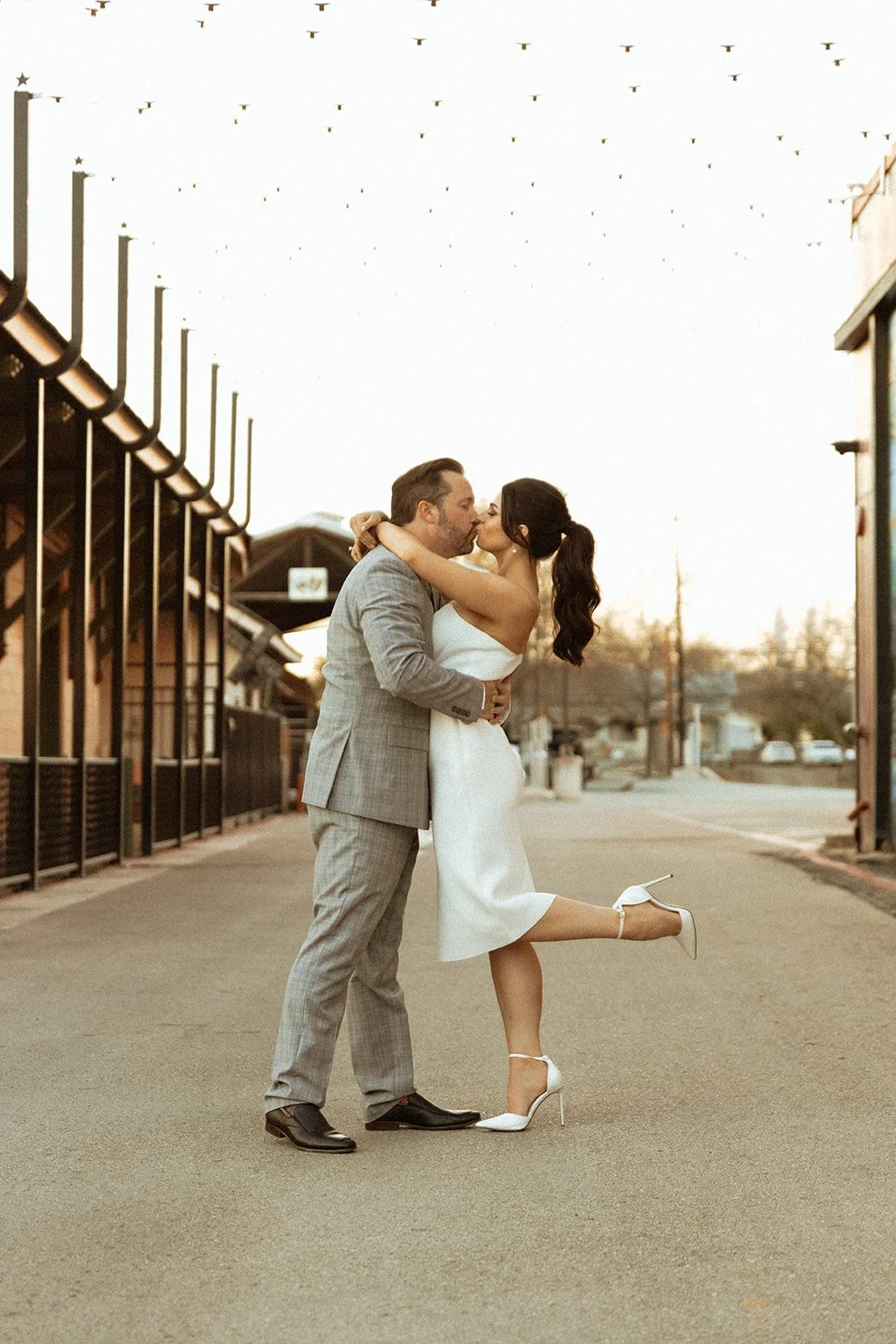 Bride and groom kissing in a charming vintage downtown area.