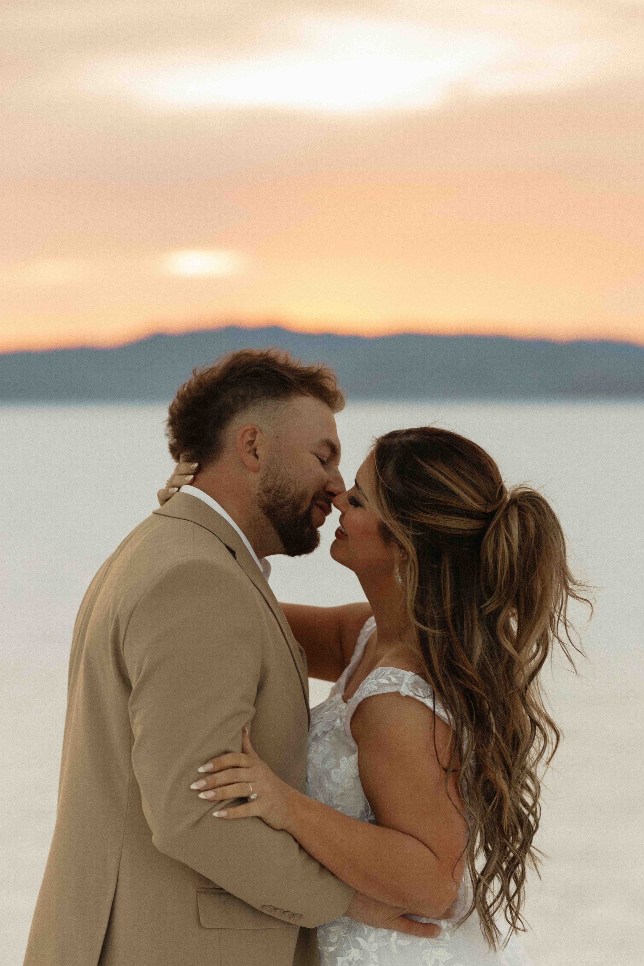 Bride and groom kissing at sunset on the Wendover Utah salt flats.