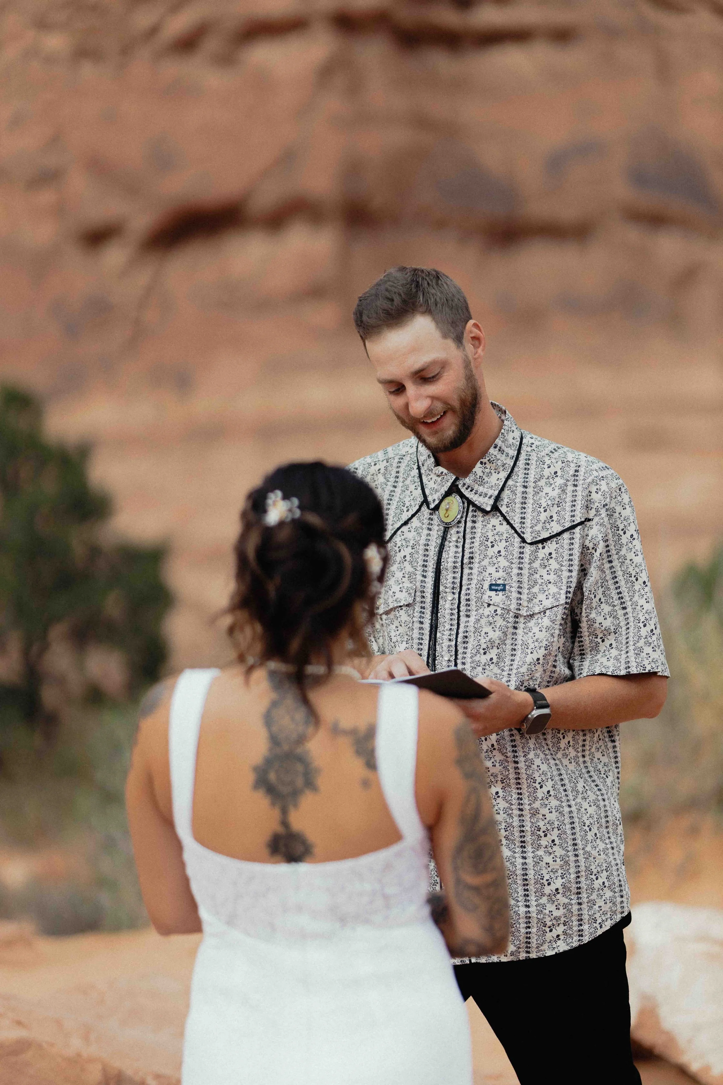 Groom reading his vows in front of red rock.