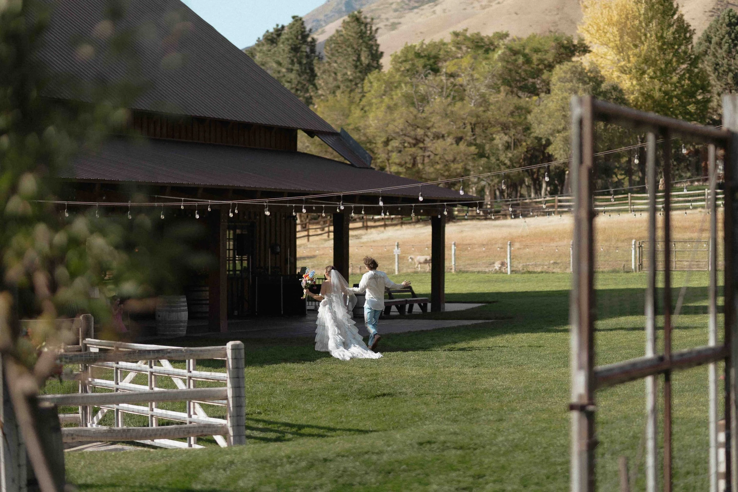 bride and groom running into a barn after their ceremony