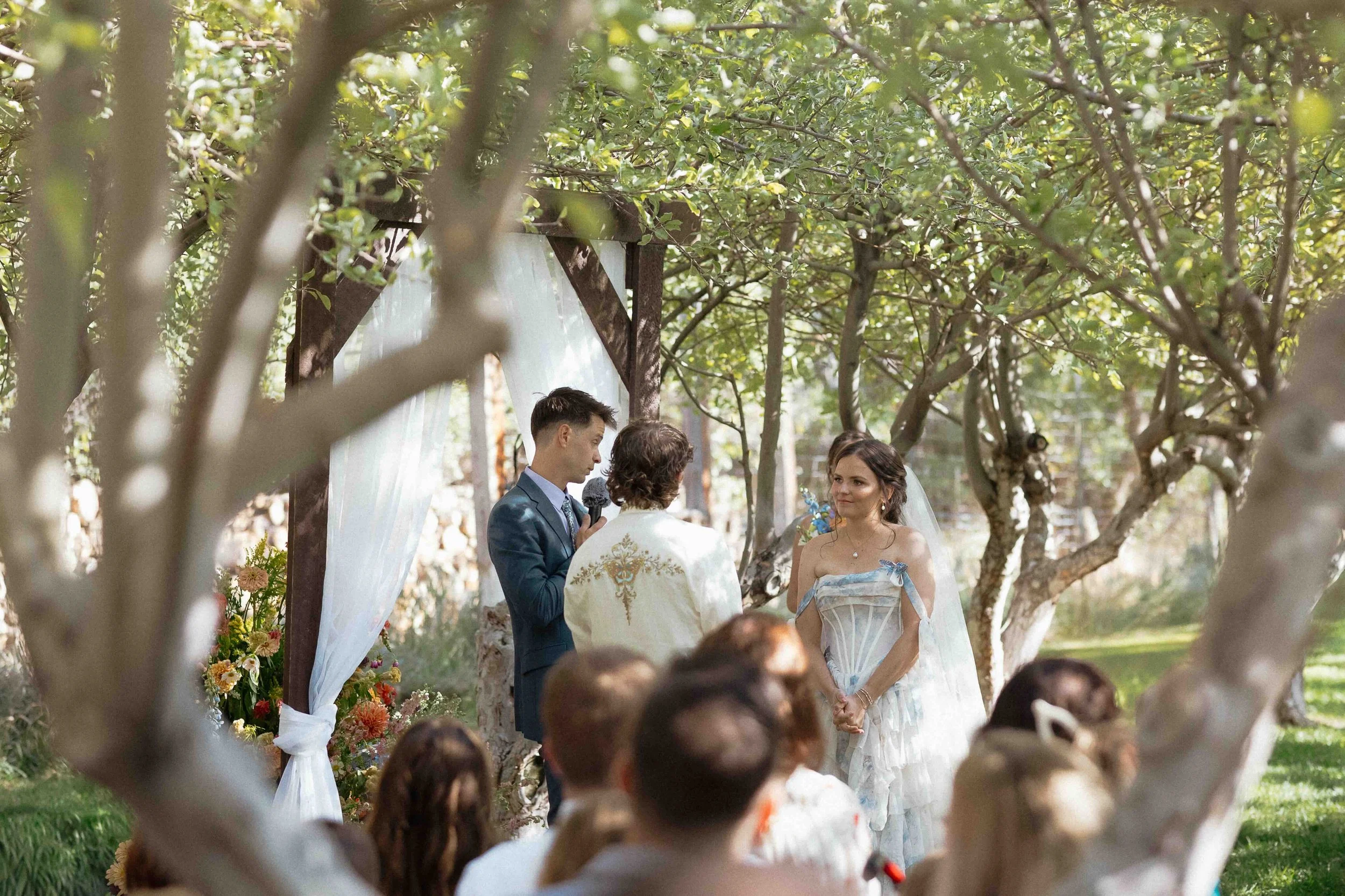ceremony in an orchard with bride and groom.