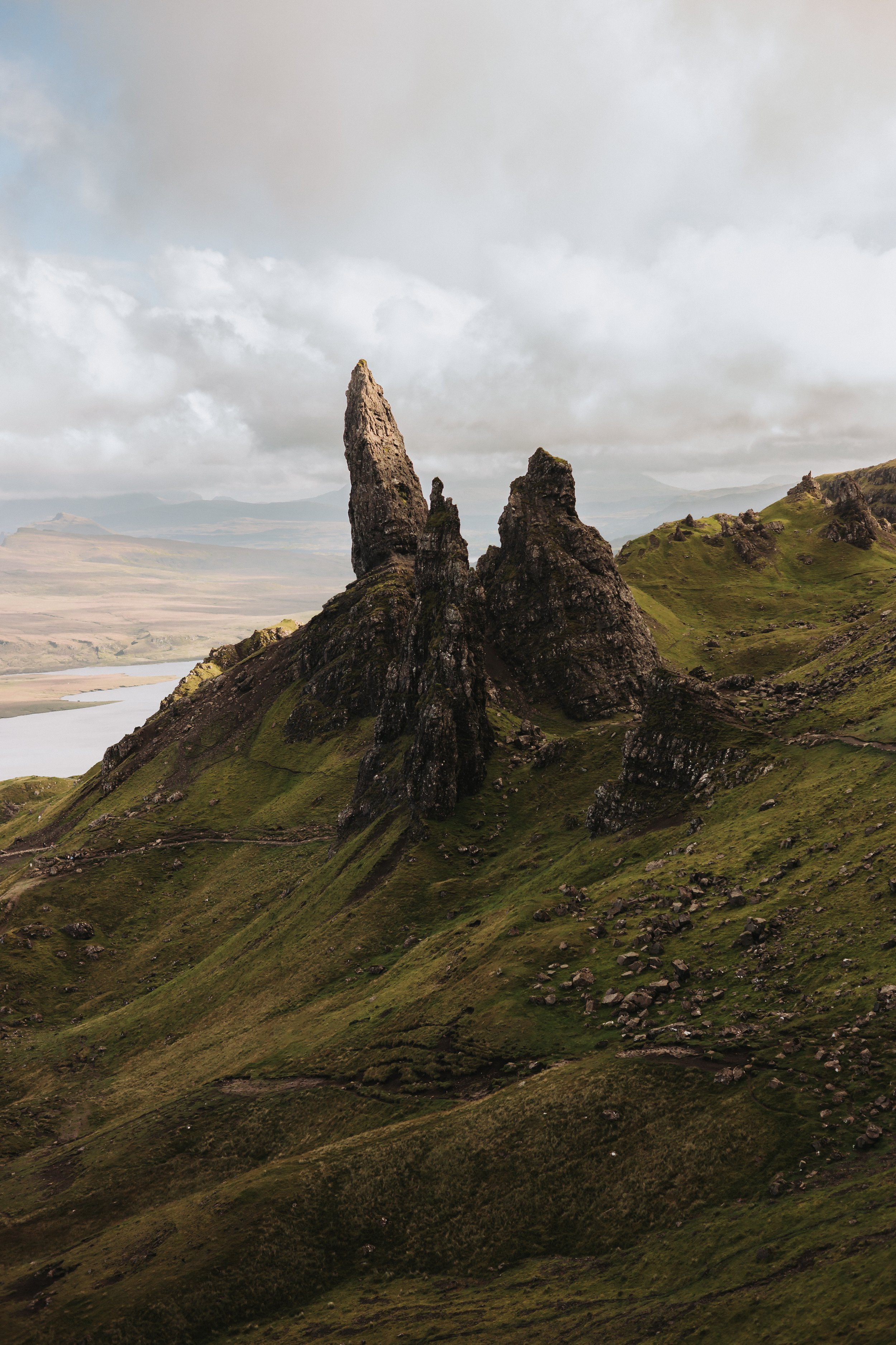 The Old Man of Storr viewpoint, of the Scottish highlands. Greenery everywhere and rocks jutting out of the hillside