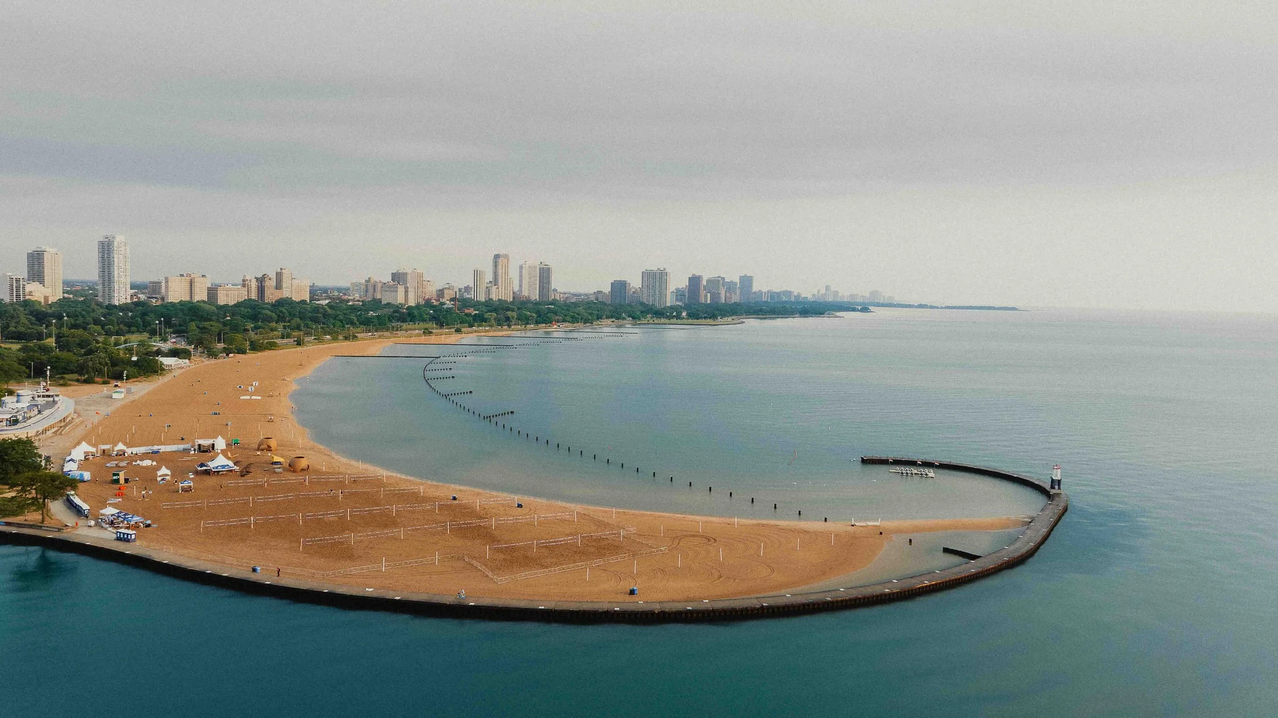A beach that juts out into Lake Michigan with the Chicago Skyline in the background.