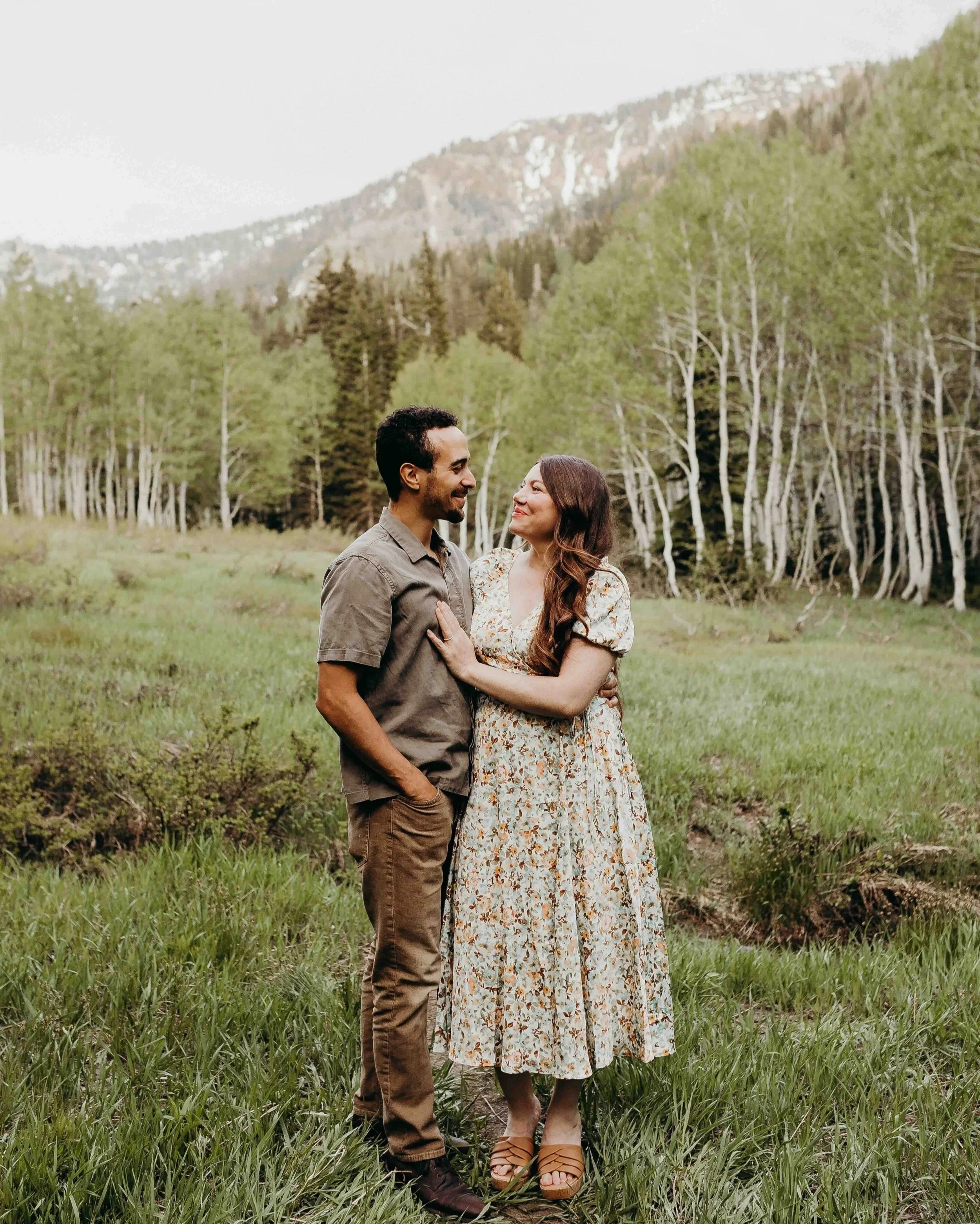 couple looking at each other in front of aspen trees and mountains.