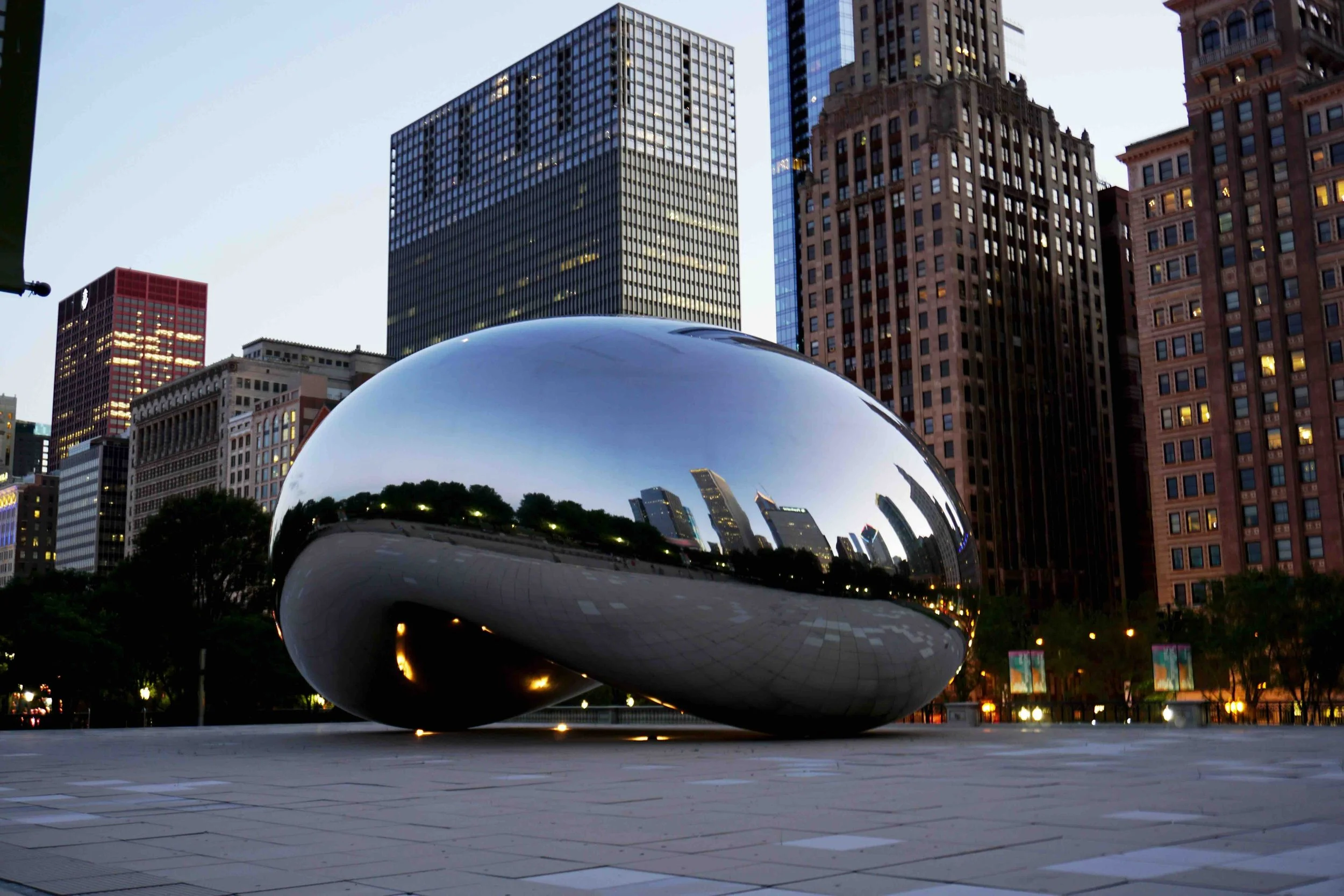 A reflective bean in the center of tall Chicago buildings.