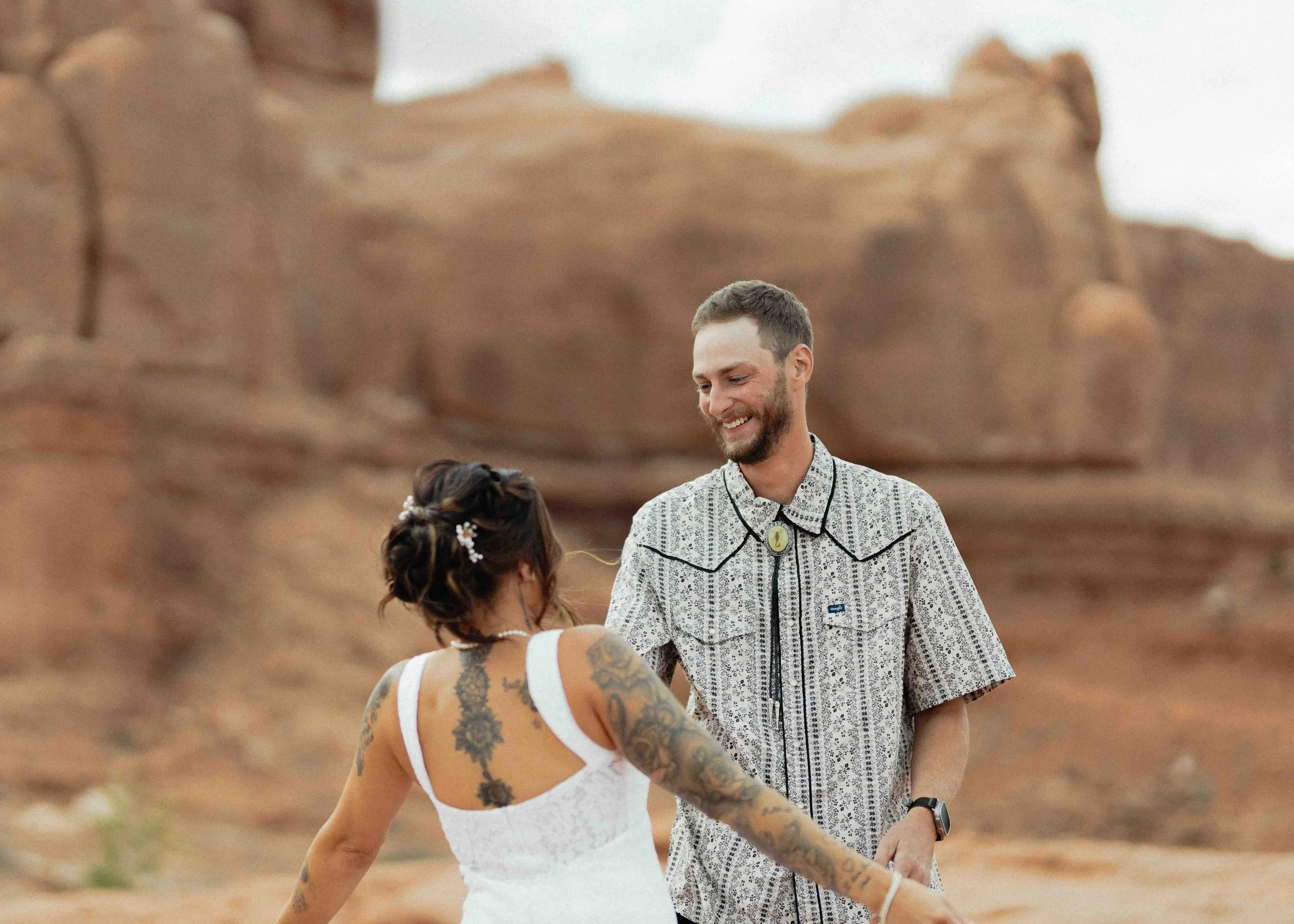 Groom seeing his bride for the first time in front of red rock formations.