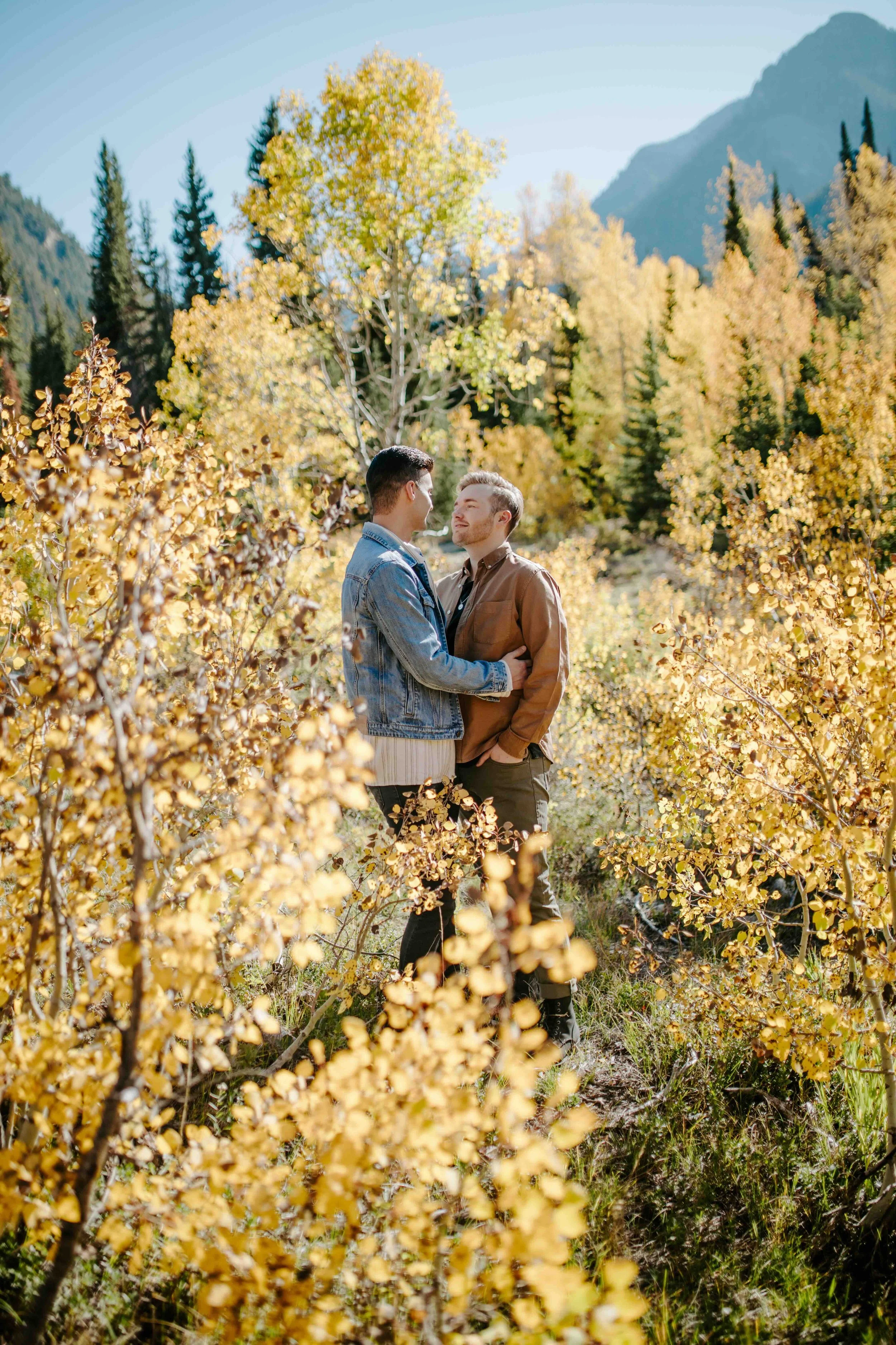 Couple embracing in the yellow aspen leaves.